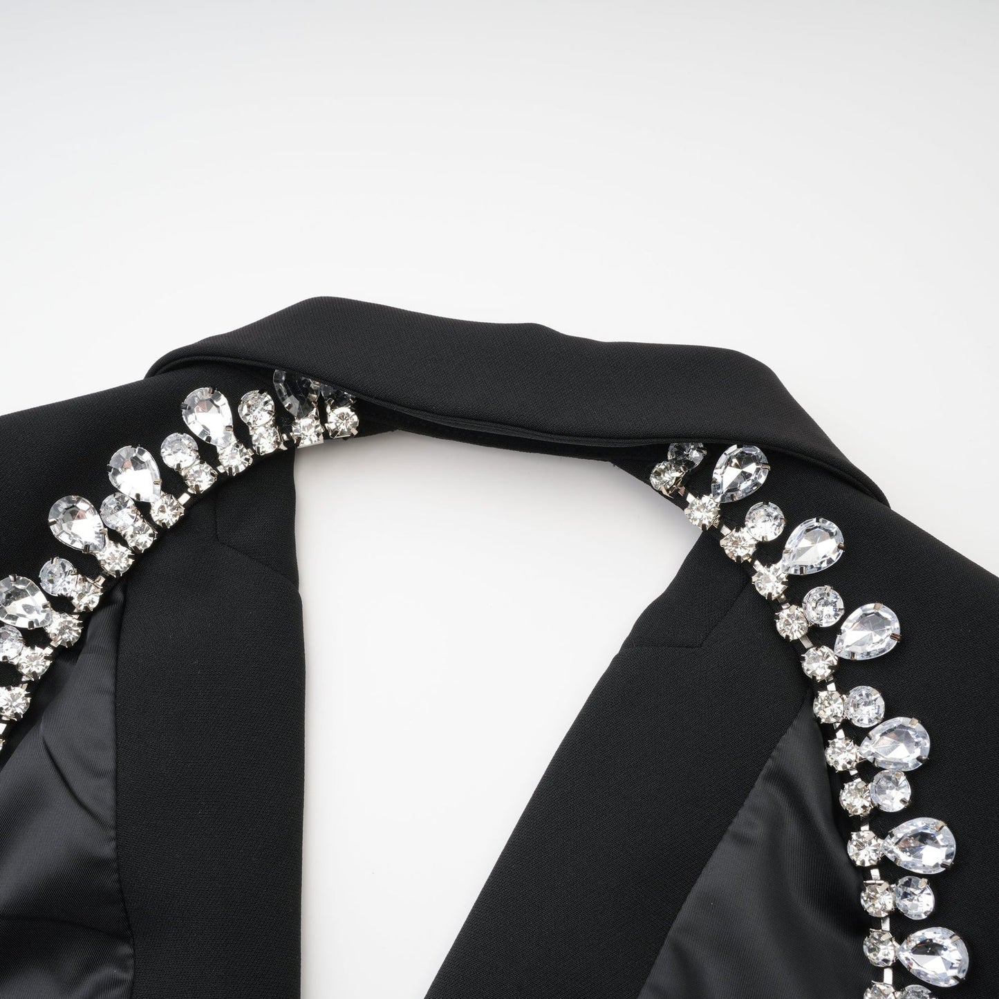 Elegant black dress with long sleeves notched lapels scoop back buttoned cuffs fitted waistline and crystal embellishment % Polyester