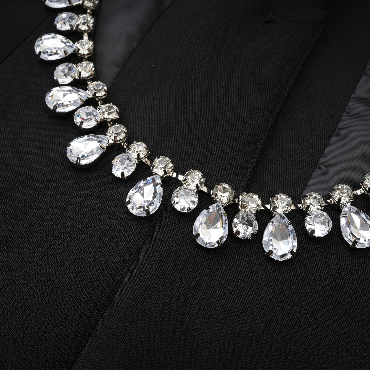 Black dress with long sleeves notched lapels scoop back buttoned cuffs fitted waistline crystal embellishment and front button fastening 100% Polyester
