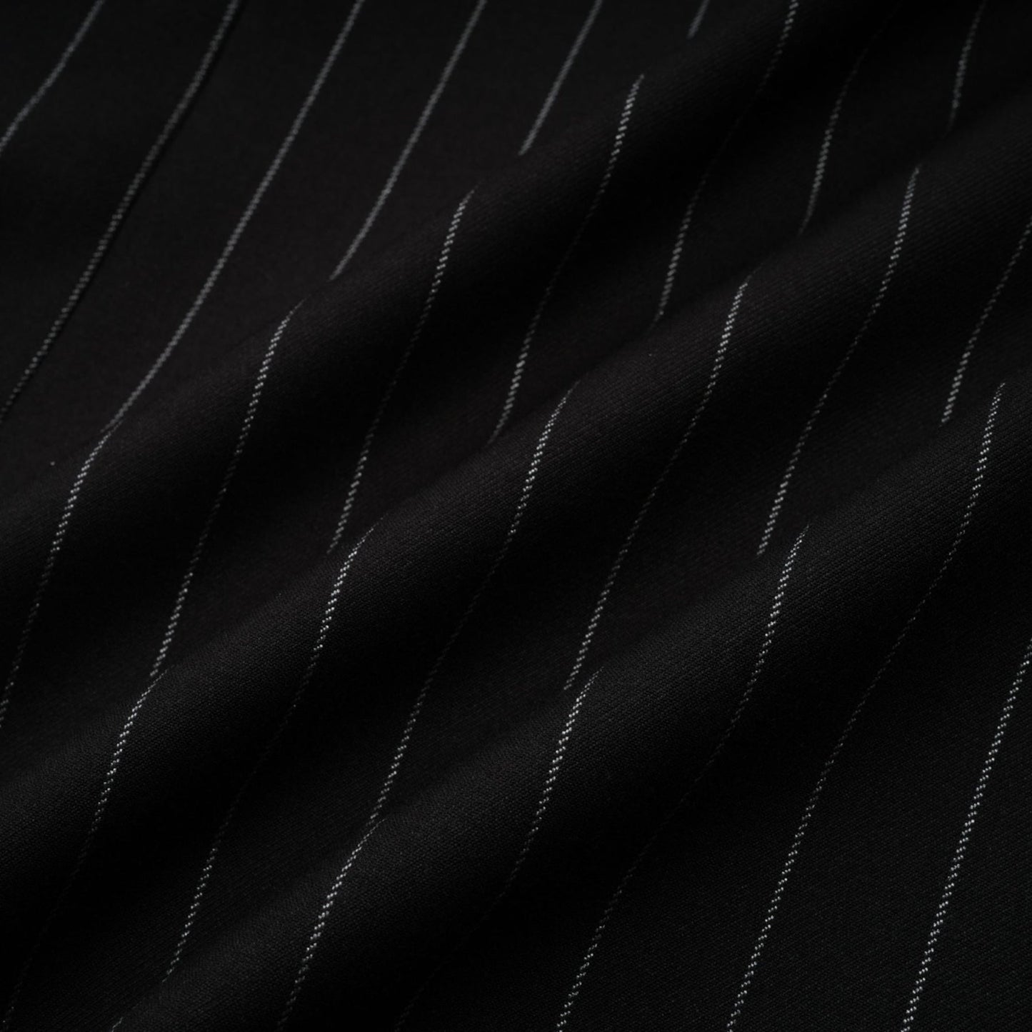 Woman wearing a black blazer with white stripes and an open back design