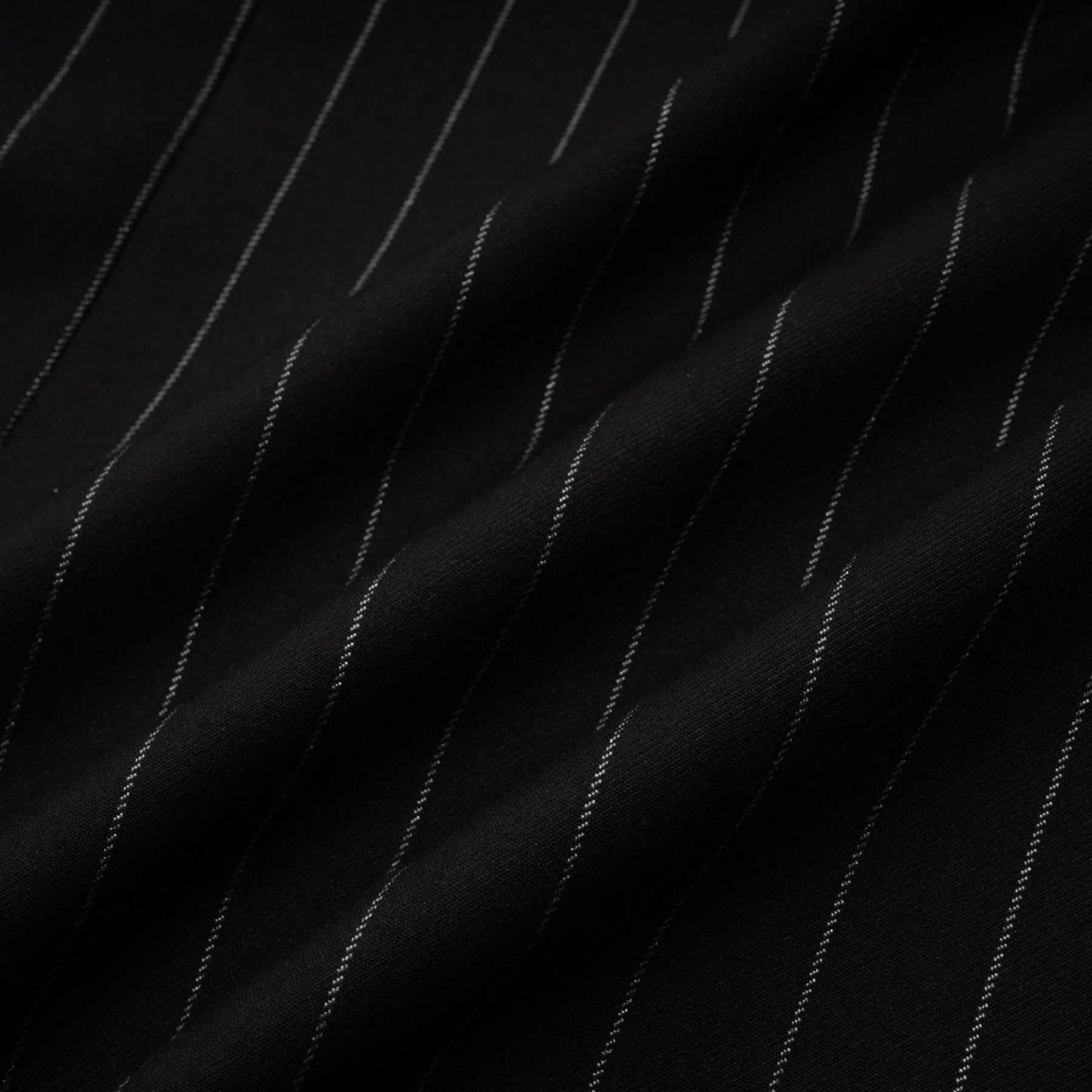 Woman wearing a black blazer with white stripes and an open back design