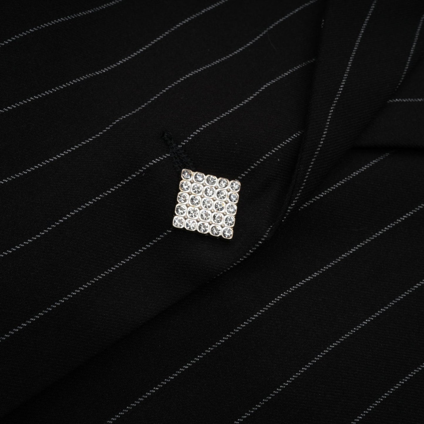 Woman wearing a black blazer with white stripes and open back design