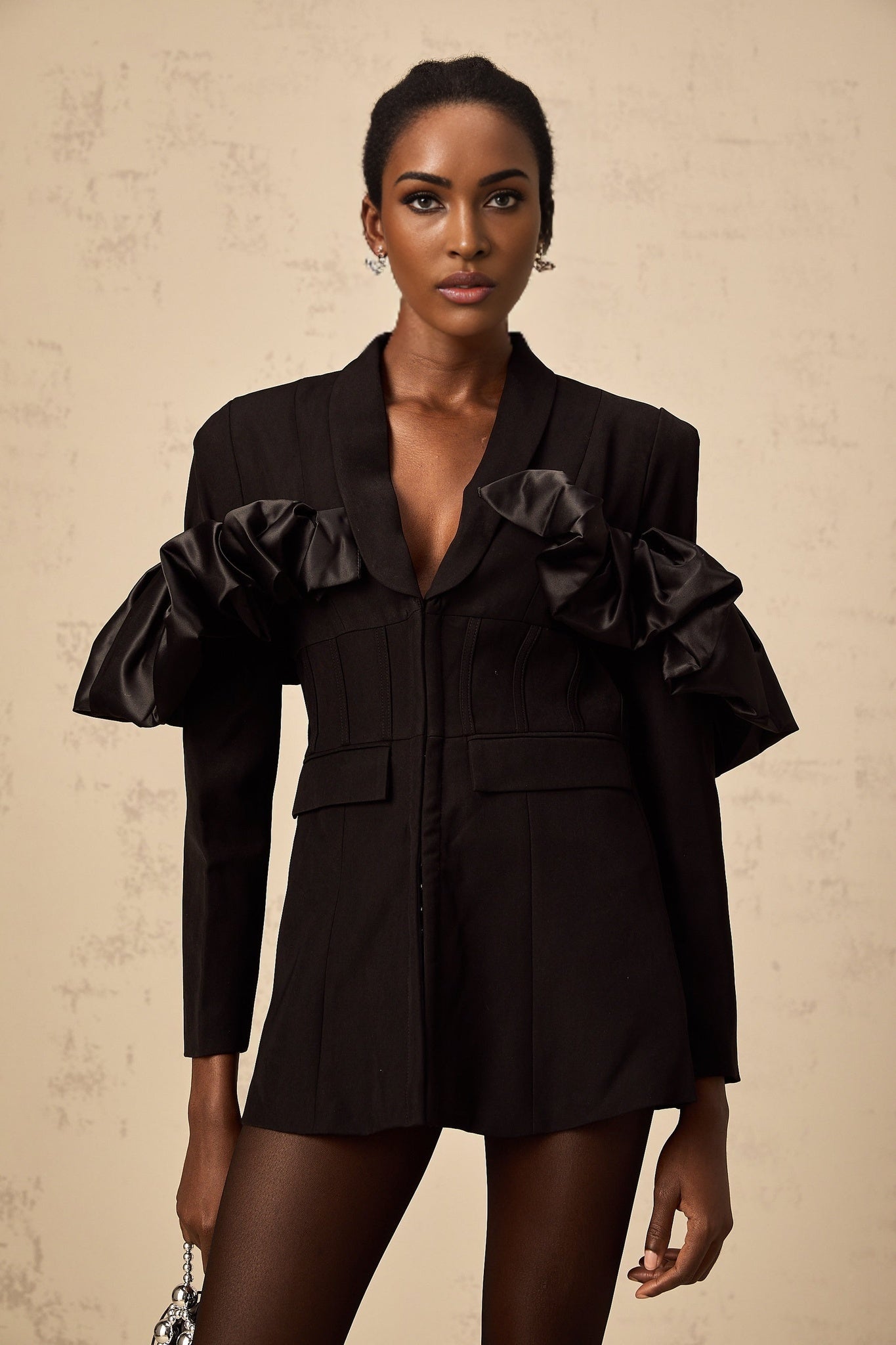 Woman wearing a black fitted blazer with panelled design and boned structure
