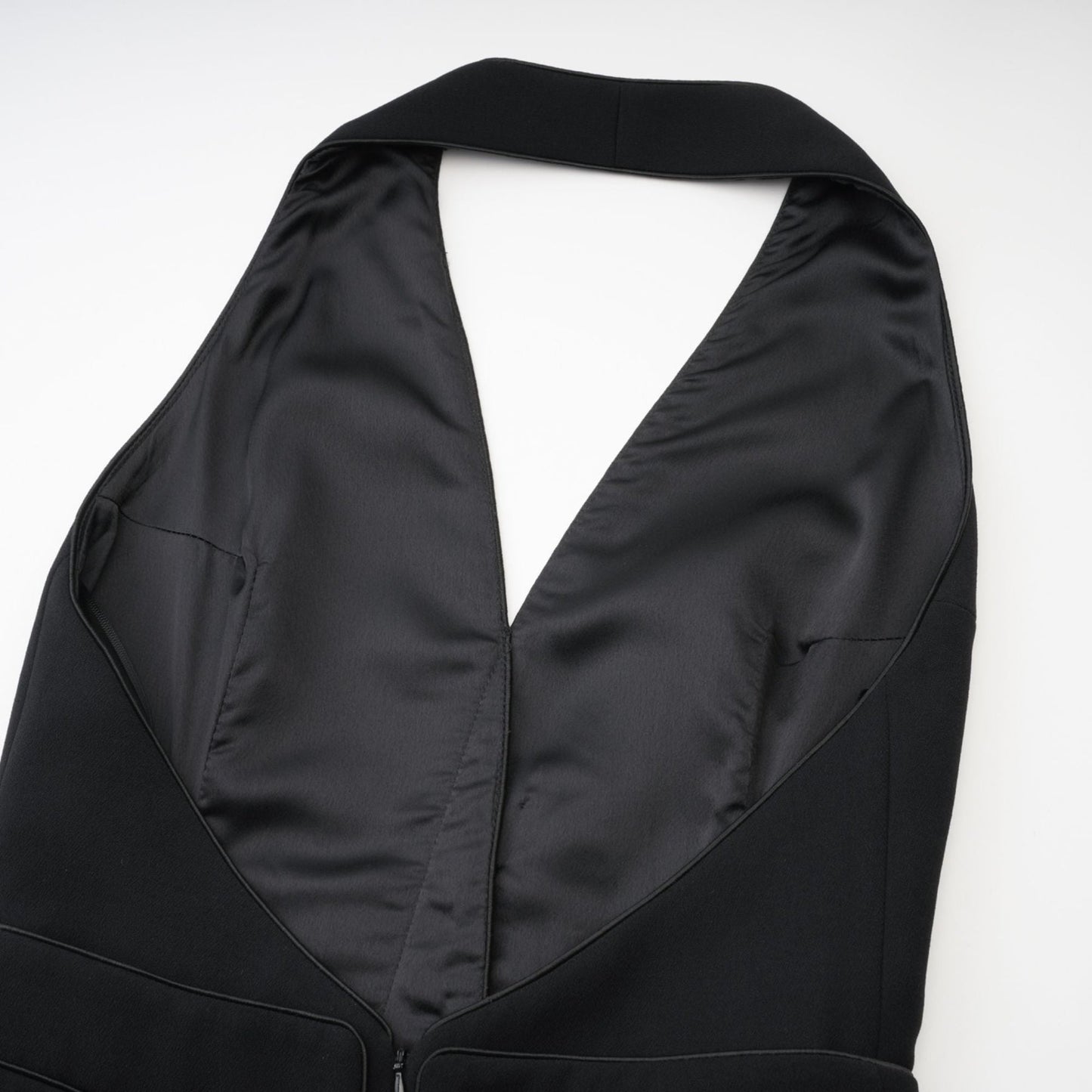 Sleek black dress with stylish halter neck sleeveless cut golden front buttons Zip fastened ends at thigh length 80% Polyester 20% Cotton for comfort
