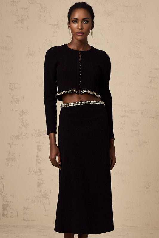 Woman wearing a black knitted cardigan and matching skirt set with embellishments named Magali