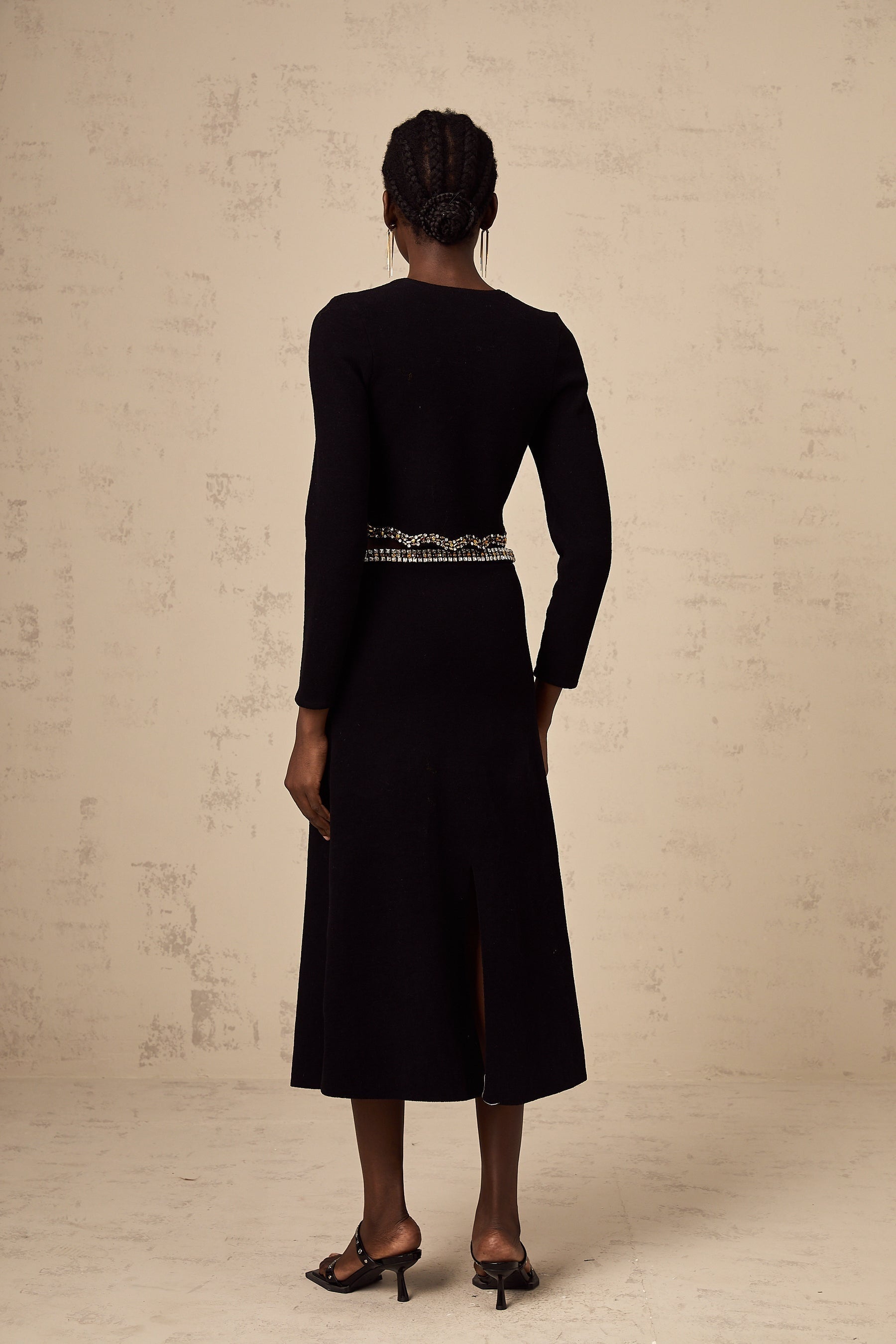 Woman wearing a black knitted cardigan and matching skirt set with embellishments named Magali