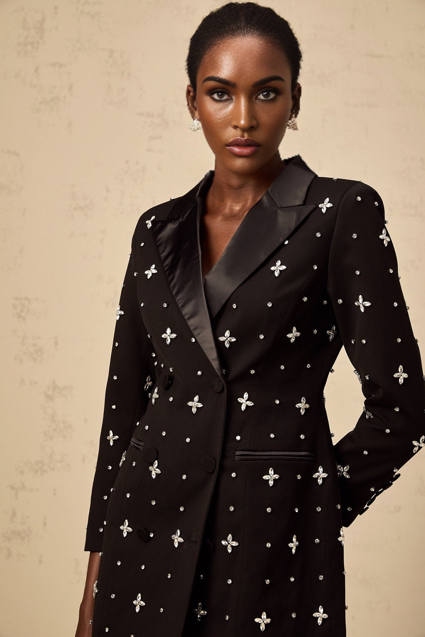 Woman wearing a black mini blazer dress with crystal panels and a fitted silhouette