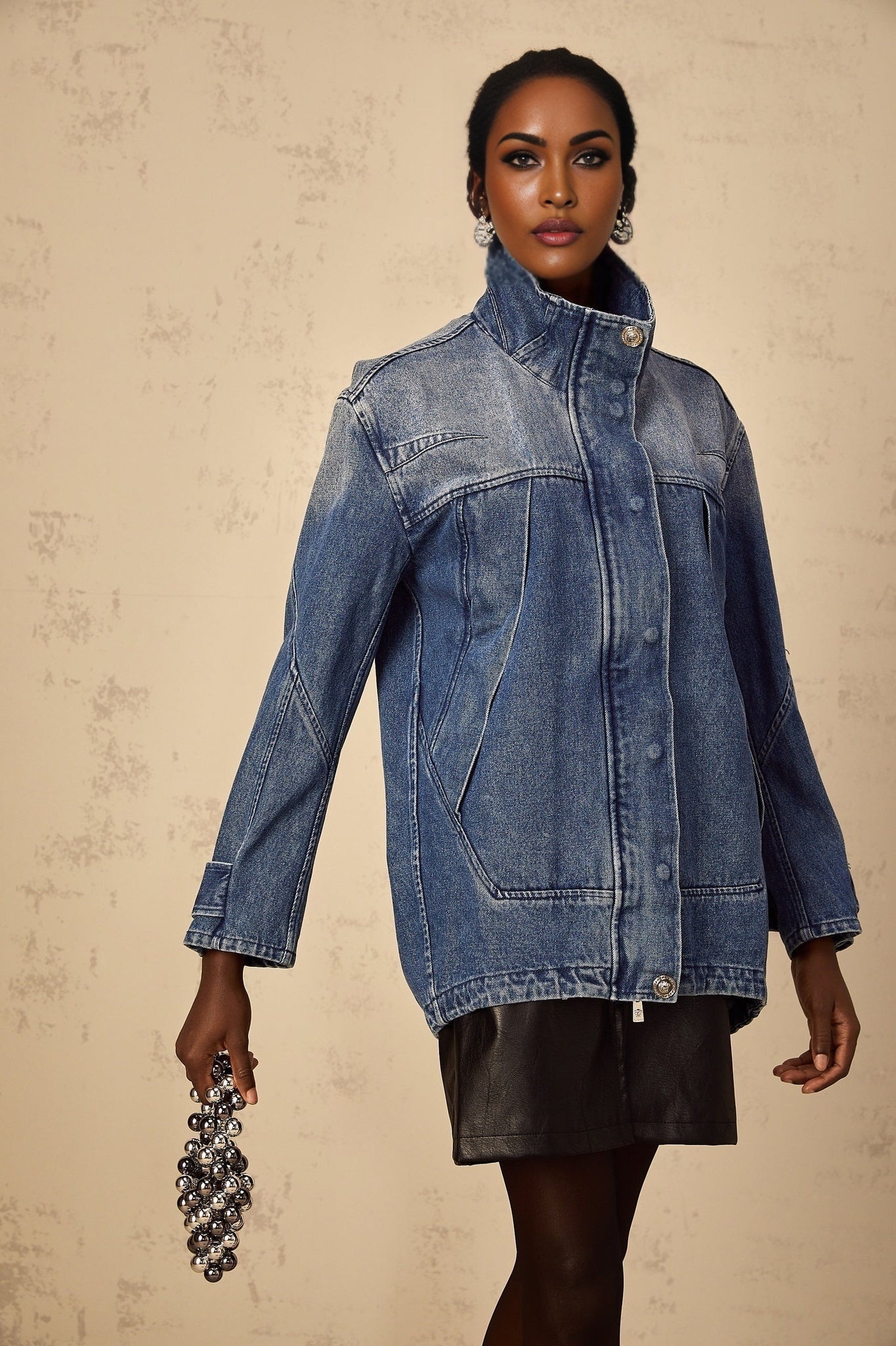 Woman wearing a blue patchwork denim jacket with loose fit and various shades of blue denim patches