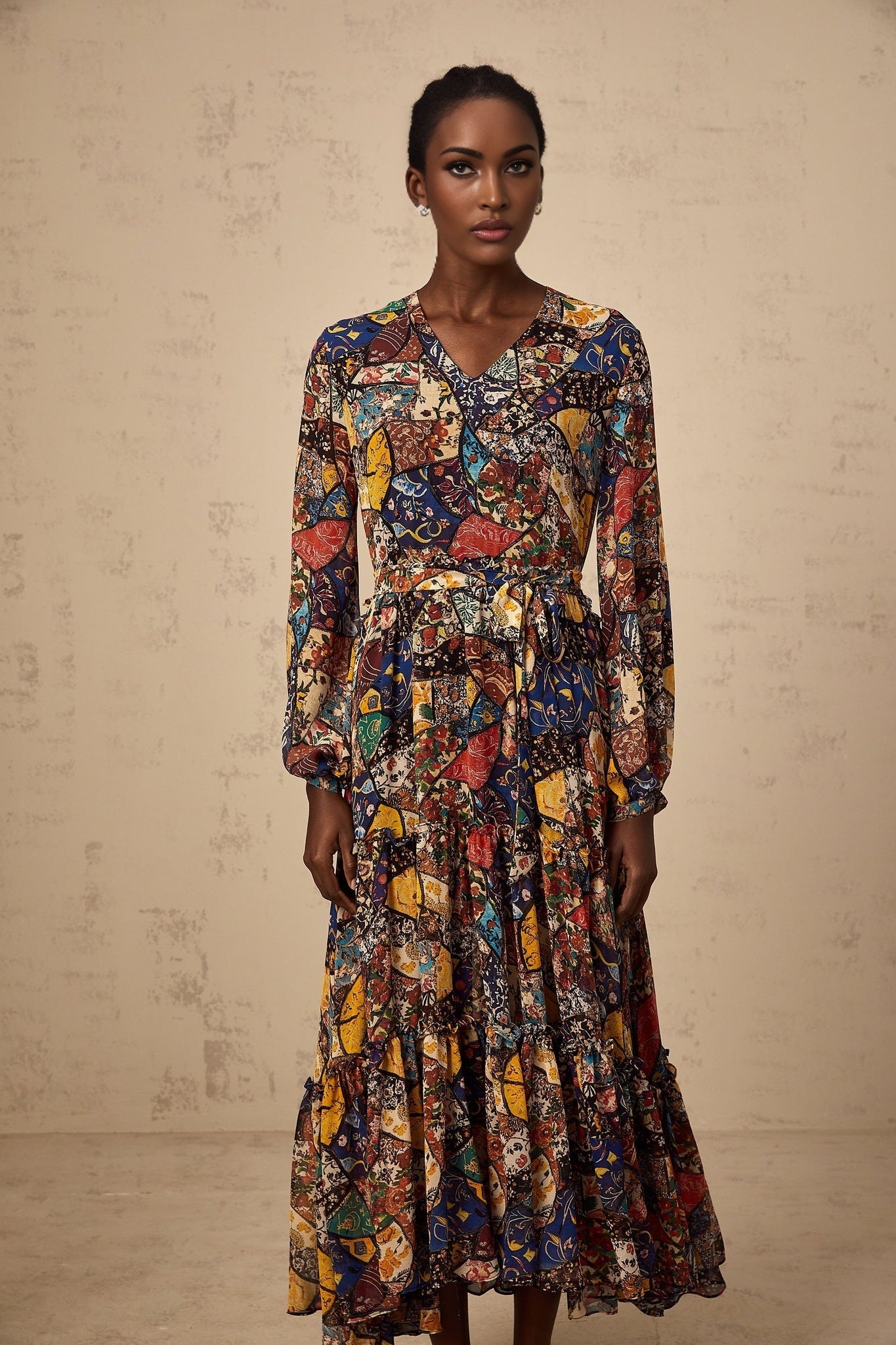 Woman wearing a brown bohemian style midi dress with shirring details and flowy sleeves in outdoor setting