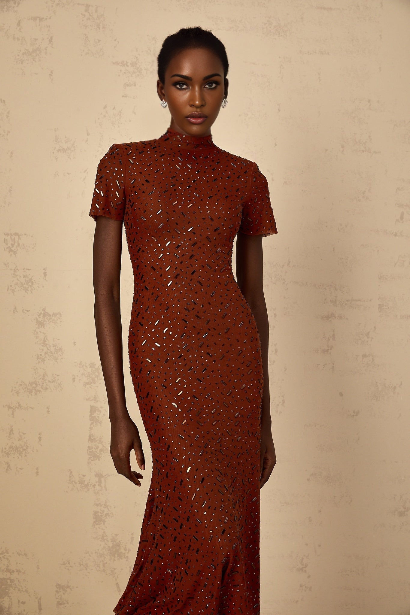 Woman wearing a brown midi dress with embellished details and a flared tulle skirt