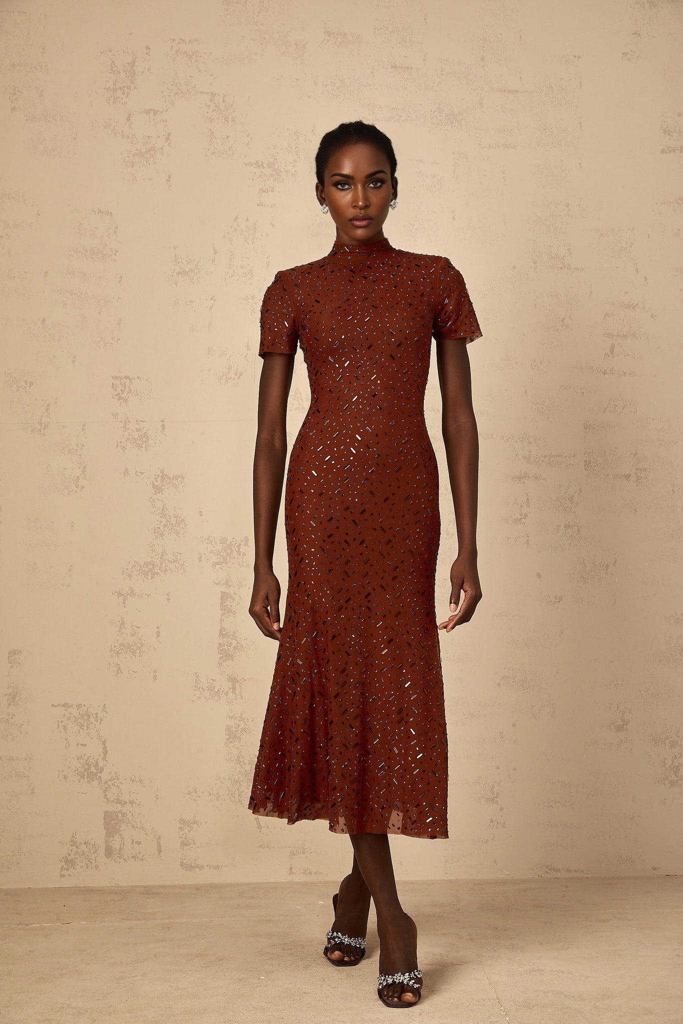 Woman wearing a brown midi dress with embellished details and flared tulle skirt