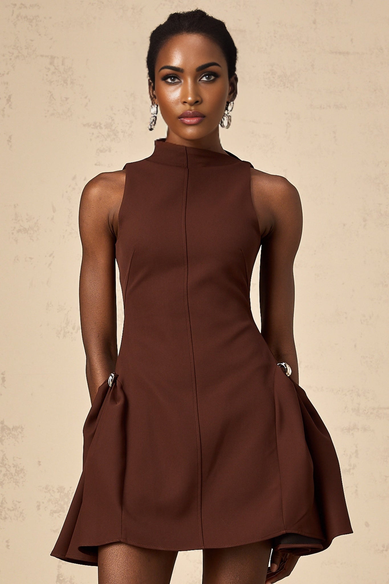 Woman wearing a brown mini dress with asymmetric neckline and puff sleeves