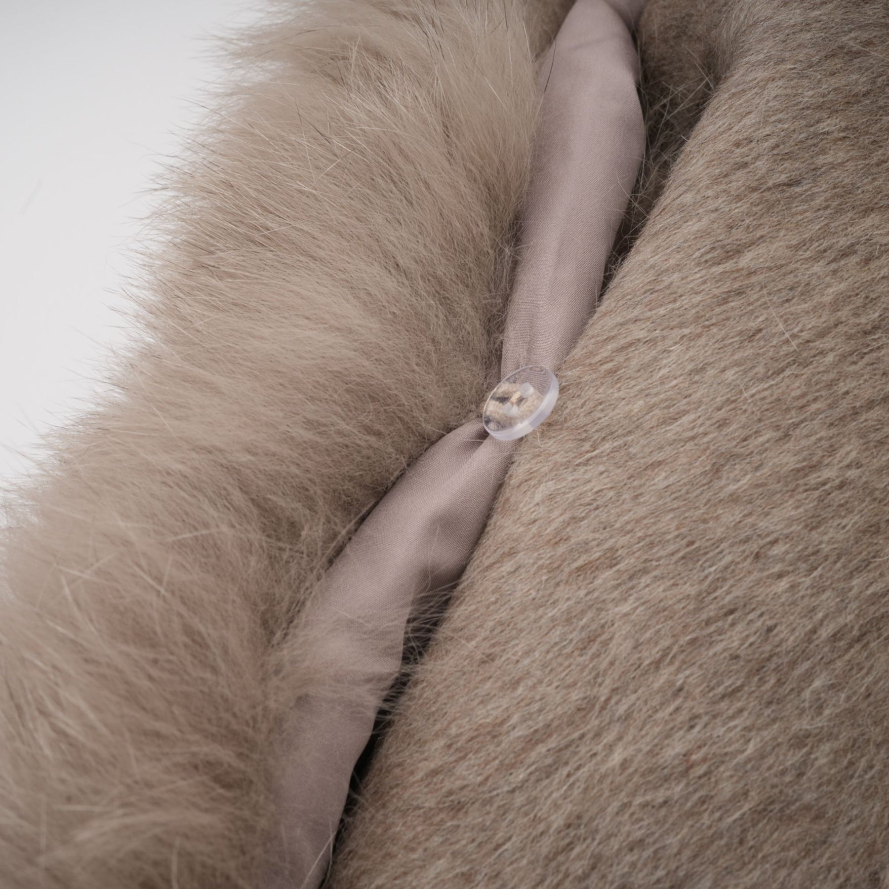 Woman wearing a brown wool cape coat with fur trim and belt