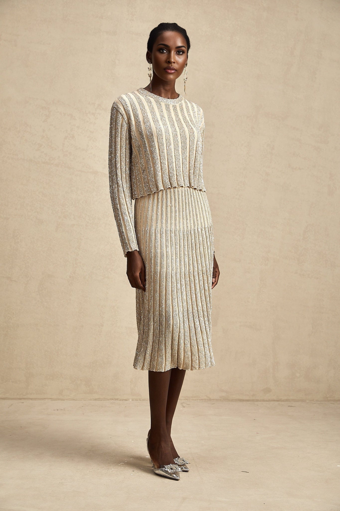 Woman wearing a champagne colored knit top and matching skirt with vertical stripes in a coordinated set named Aurore