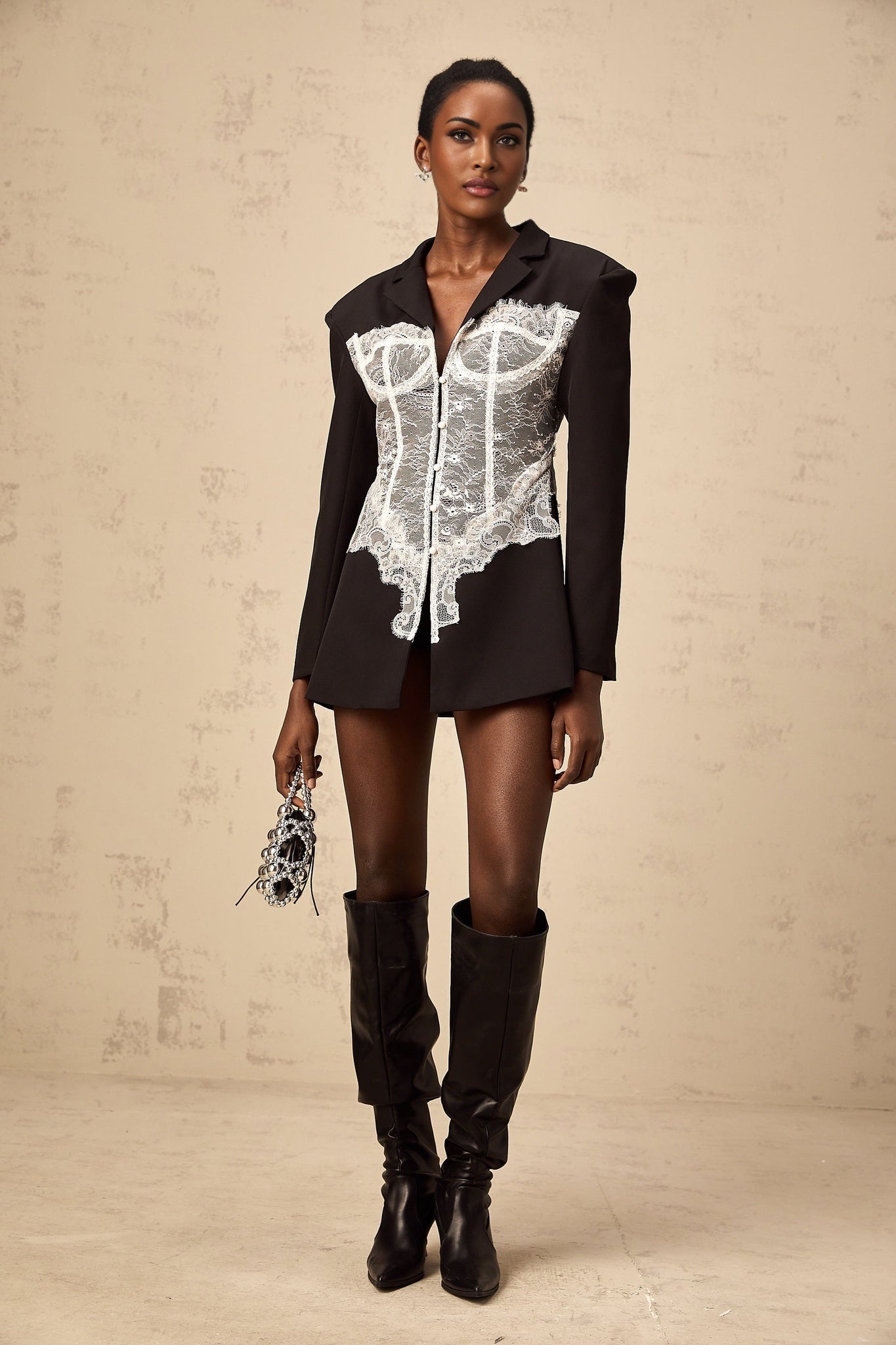 Woman wearing a colorblocked blazer with lace panels in contrasting colors