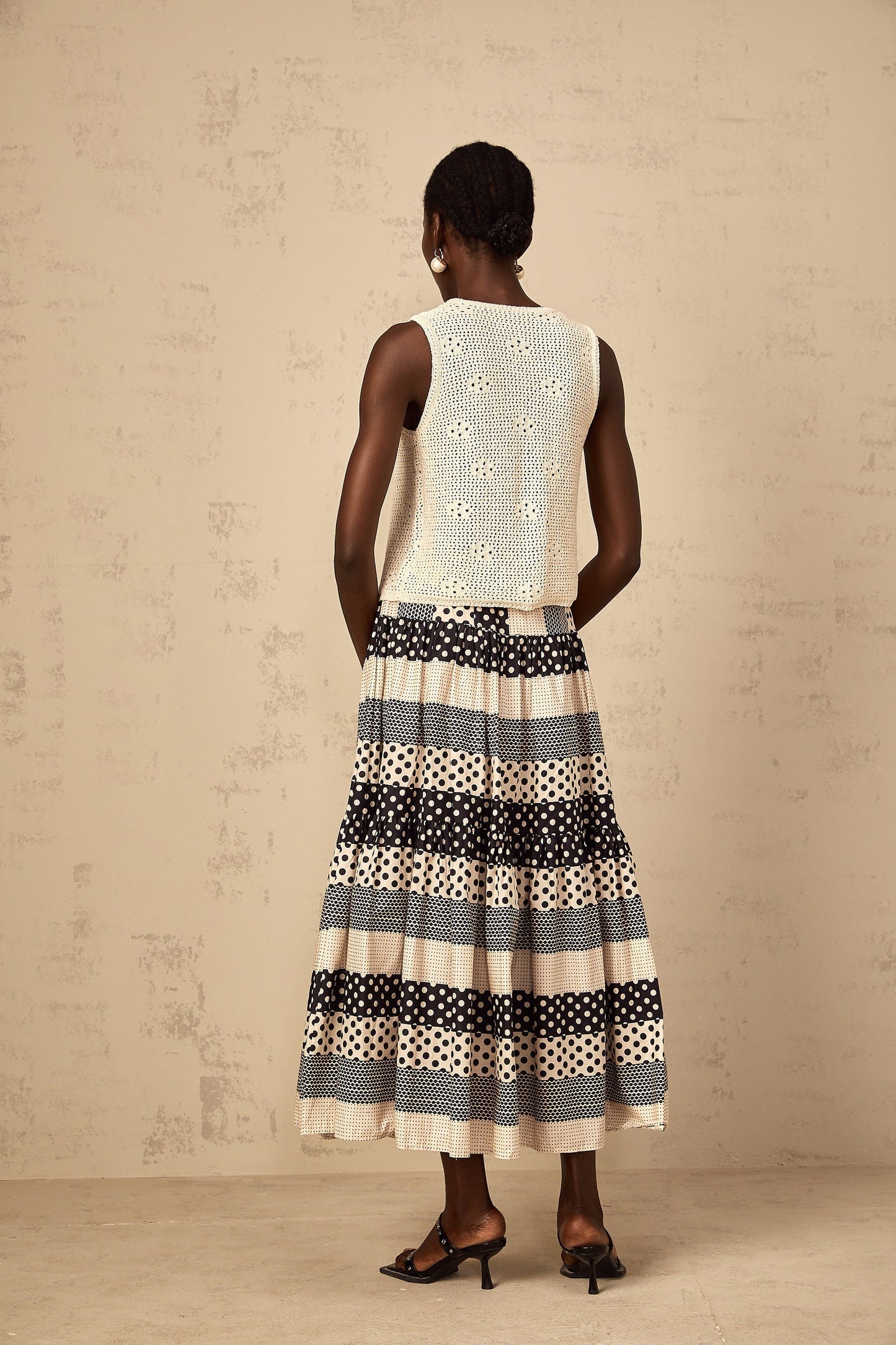 Woman wearing a colorful skirt with polka dot pattern and shirred waistband featuring color block design