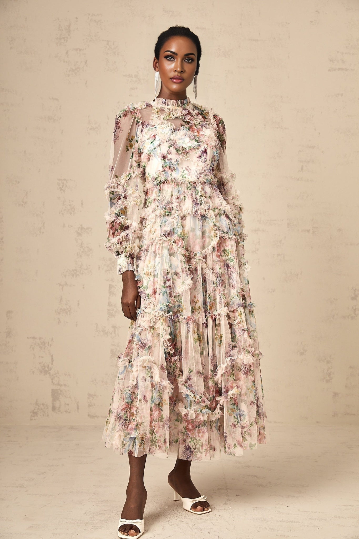 Woman wearing a floral patterned midi dress with ruffled details and tulle fabric