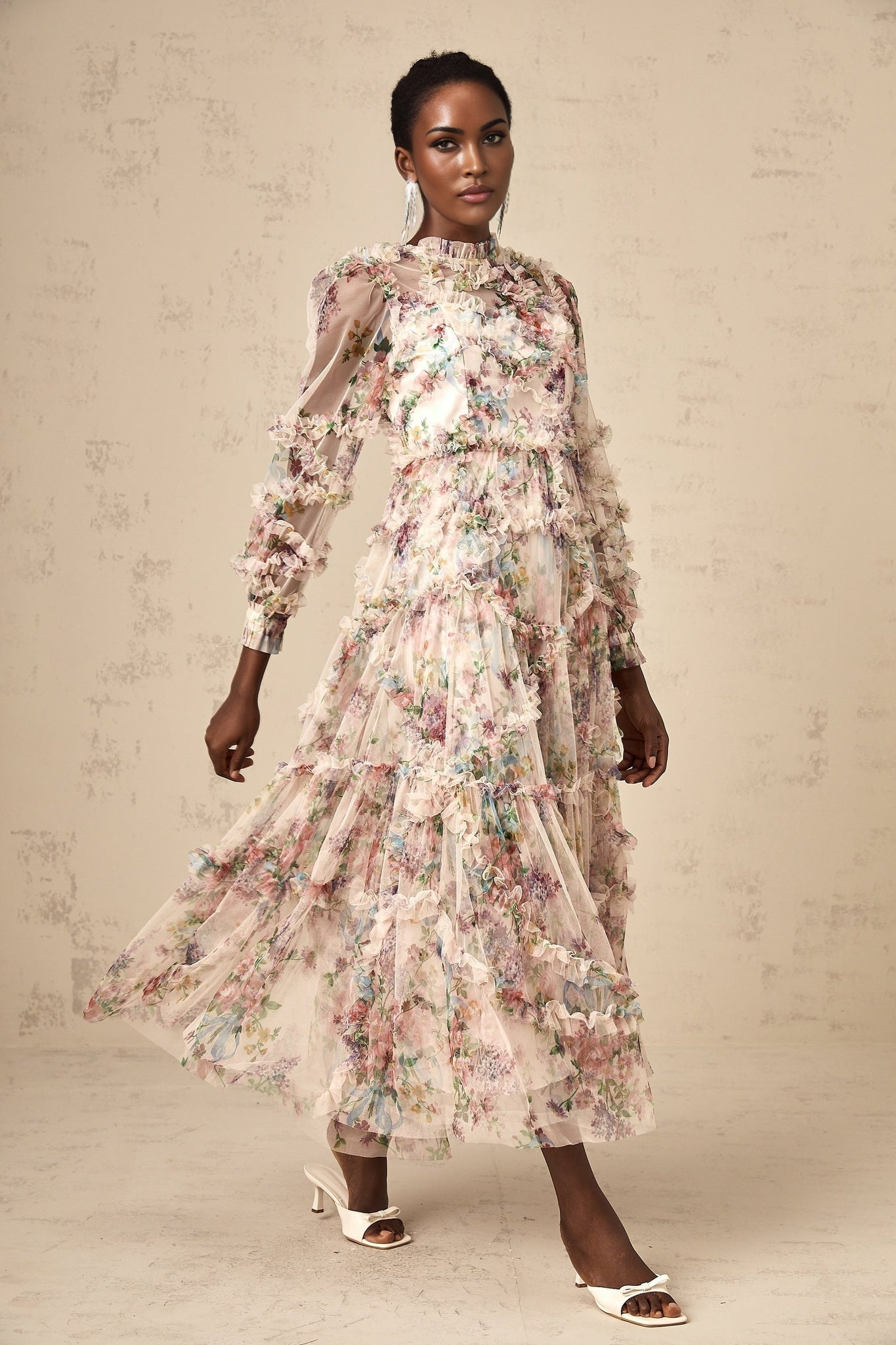 Woman wearing a floral patterned midi dress with ruffled tulle details and short sleeves