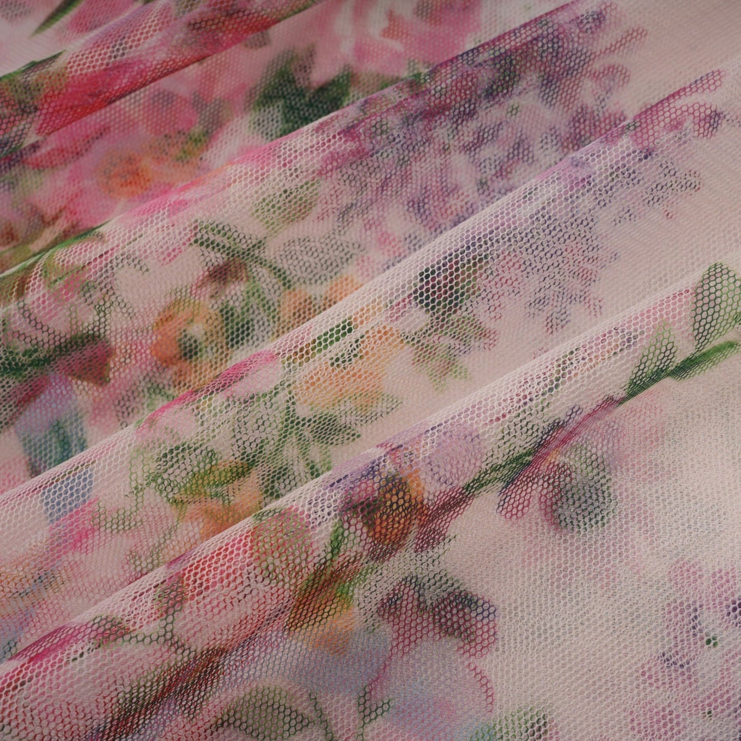 Woman wearing a floral patterned midi dress with ruffles and tulle overlay standing in a neutral background