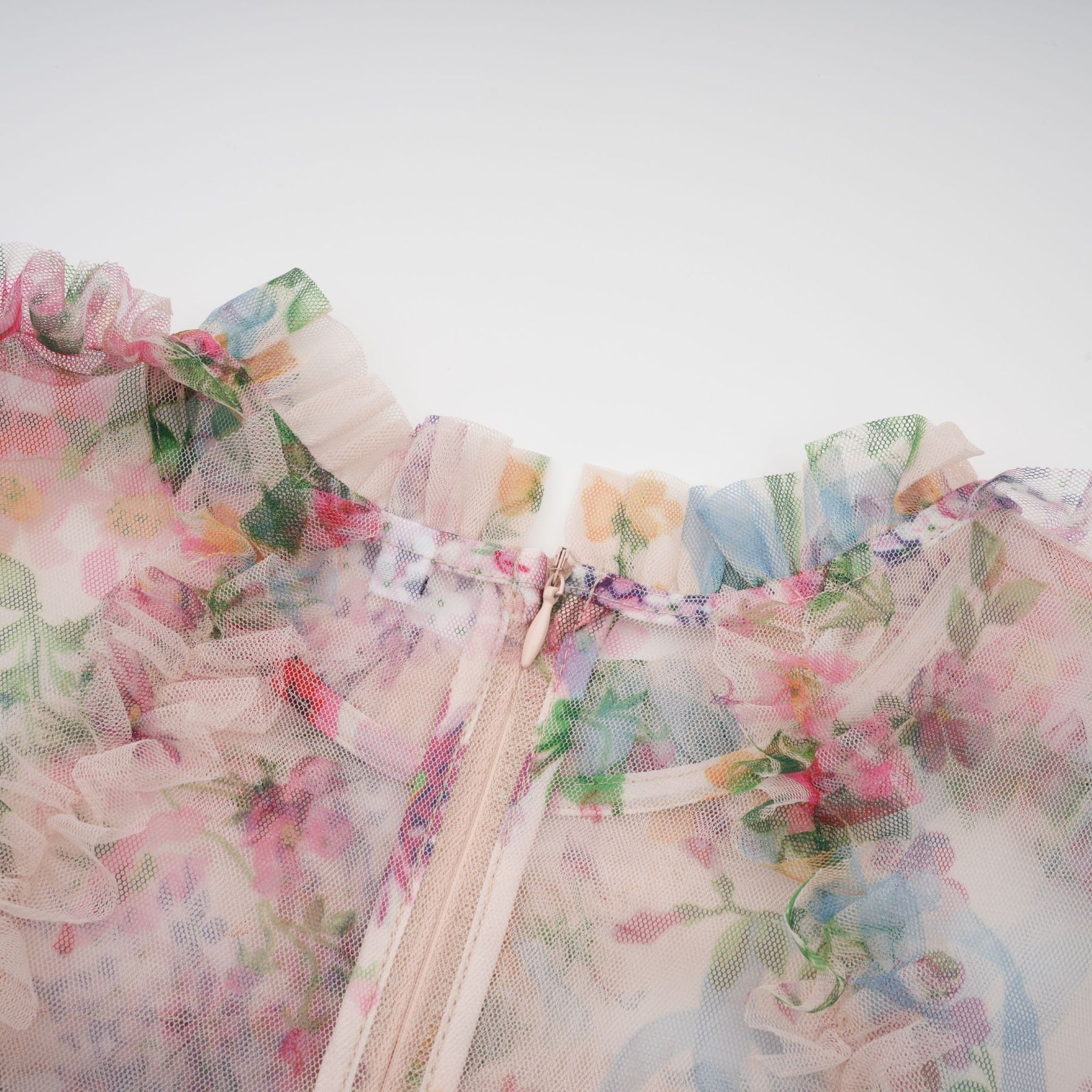 Woman wearing a floral print midi dress with ruffled tulle details and a delicate pattern