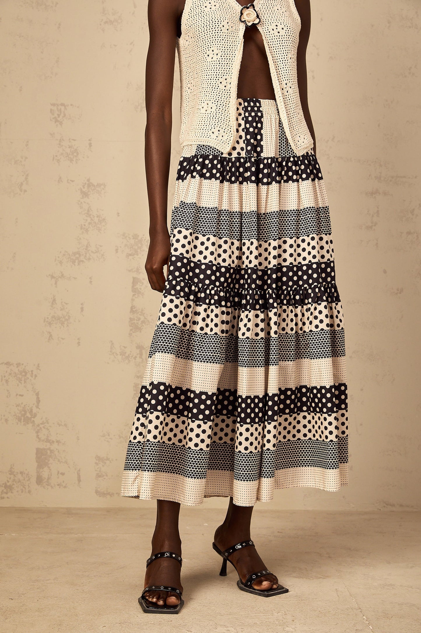 Woman wearing a knee length color block skirt with polka dot pattern and shirred waistline