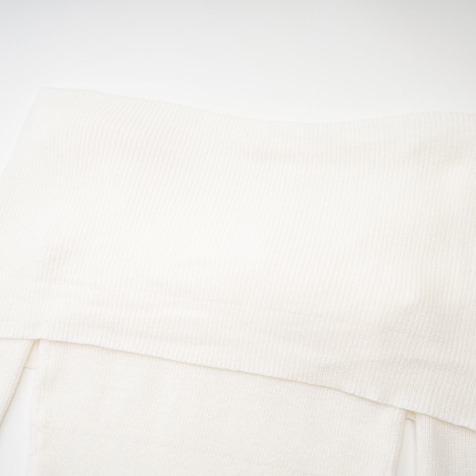 Woman wearing a knitted strapless long sleeve top in light color