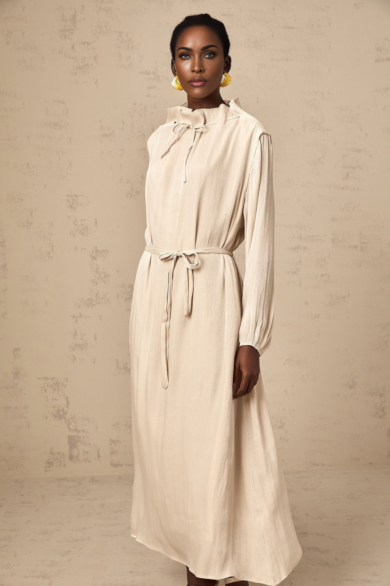 Woman wearing a light pastel tulle midi dress with self tie waist and flowy skirt
