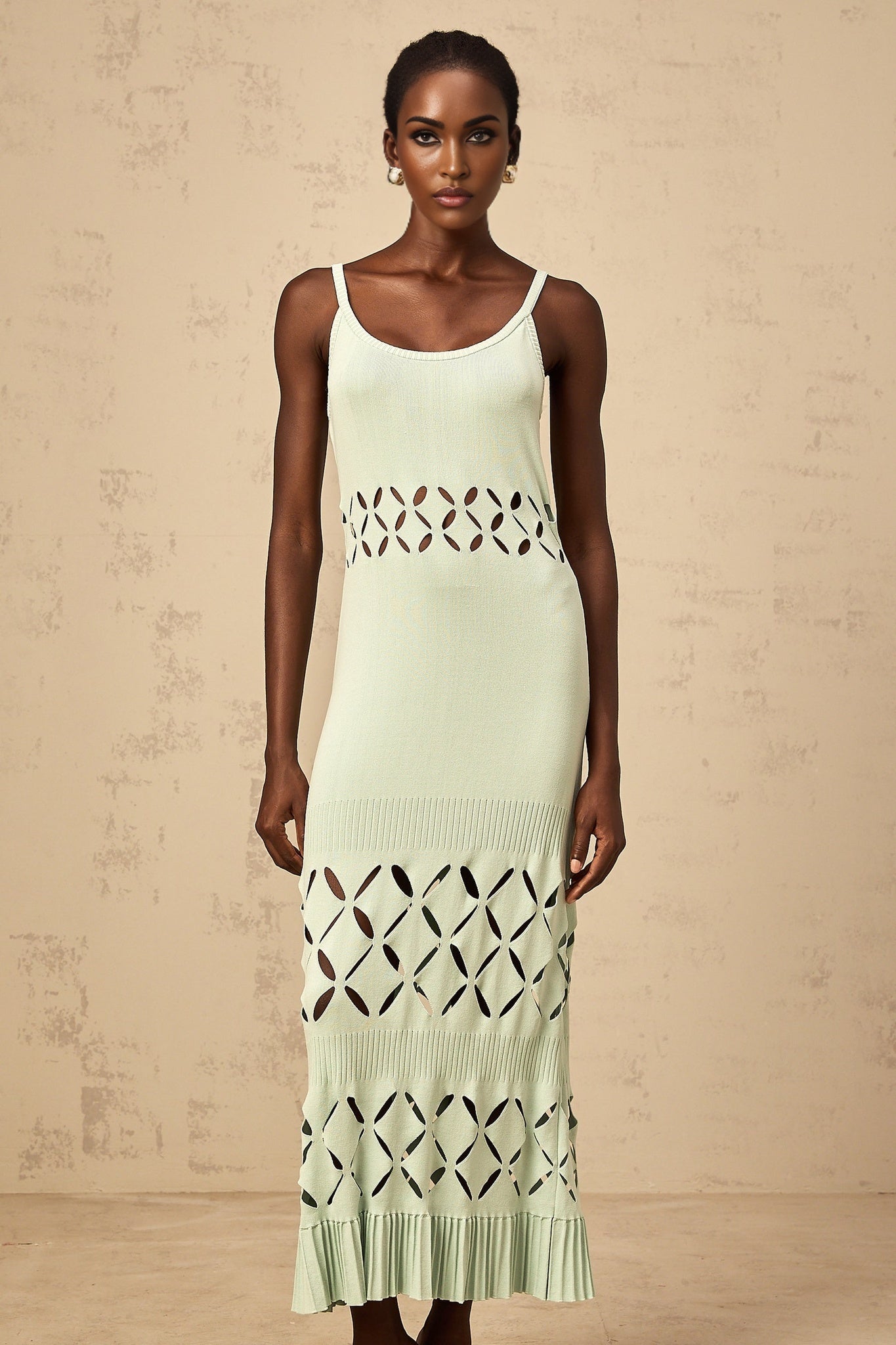 Woman wearing a long green knitted maxi dress with cutout details