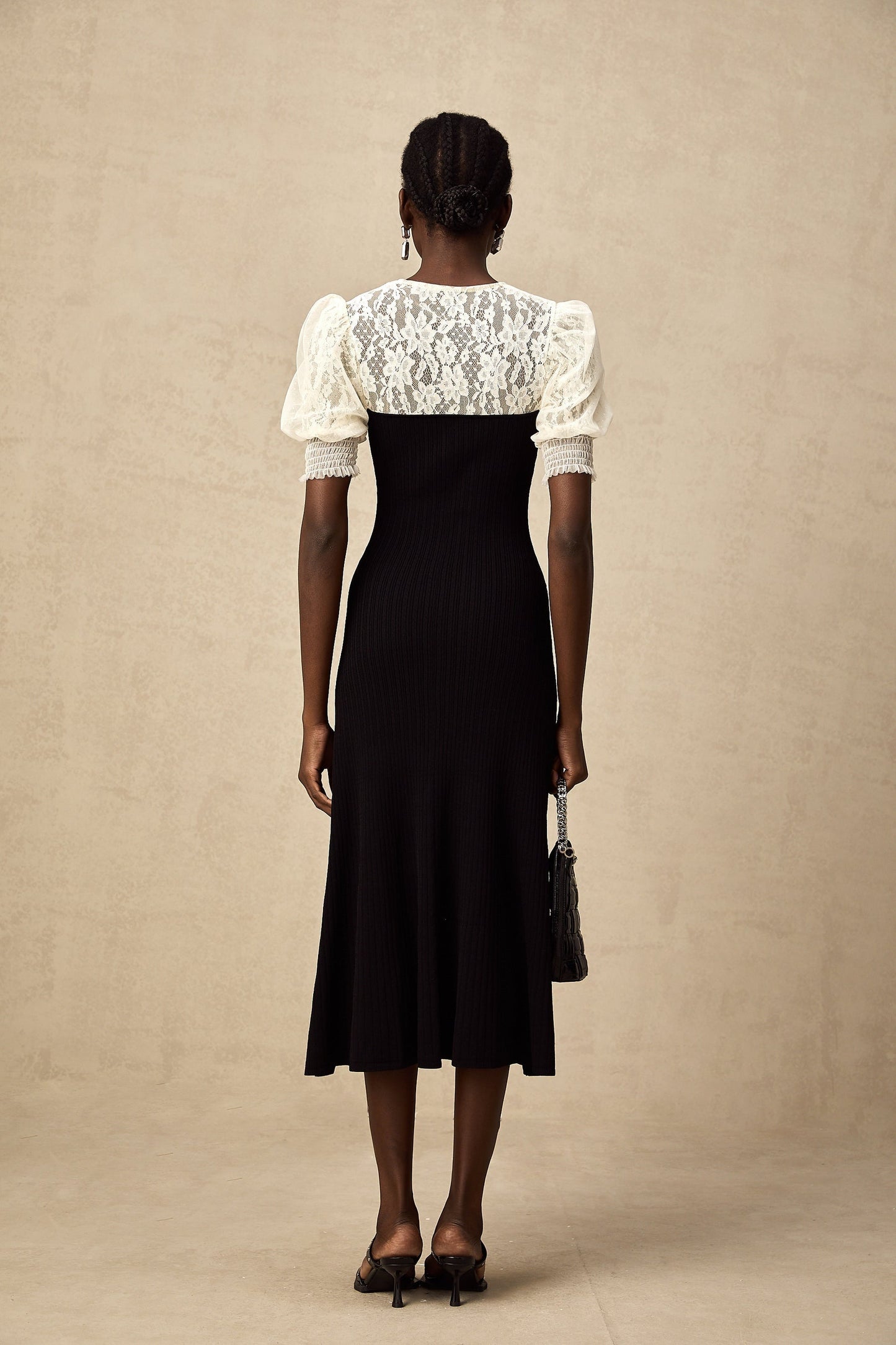 Woman wearing a long knit midi dress with lace trim details