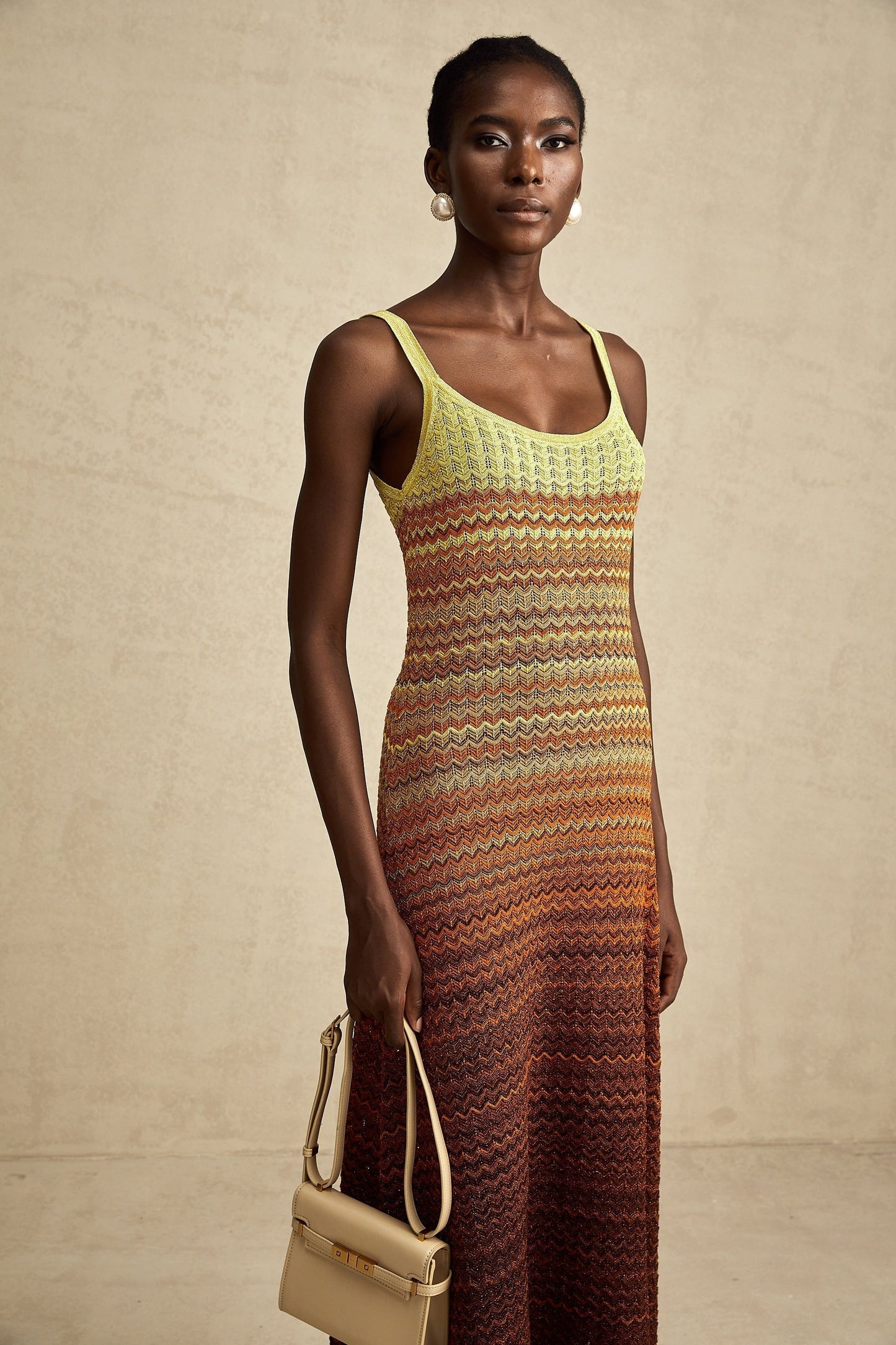 Woman wearing a long knitted maxi dress with gradient colors inspired by Audrey Hepburn style