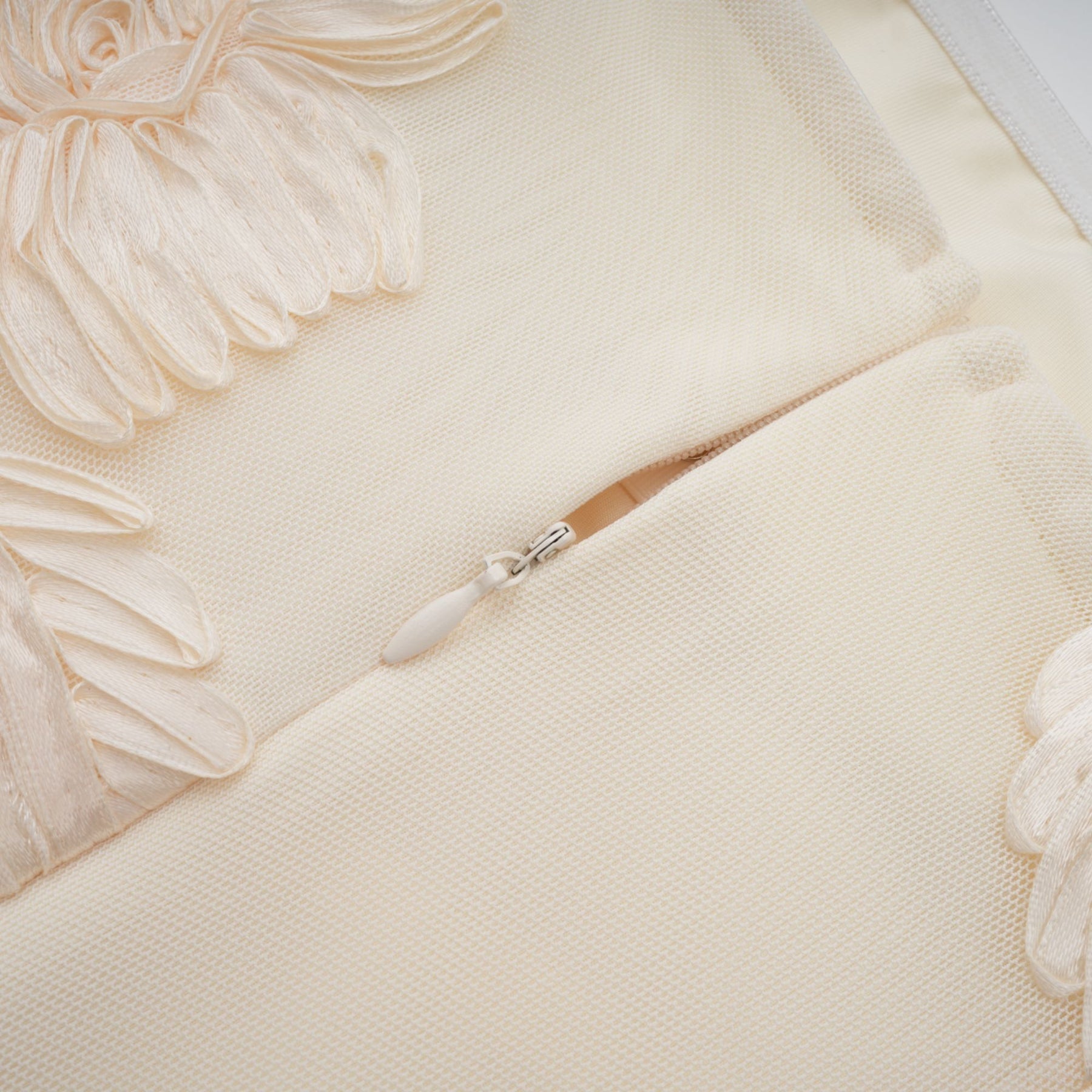 Woman wearing a long offshoulder maxi dress in neutral colors with embroidered details