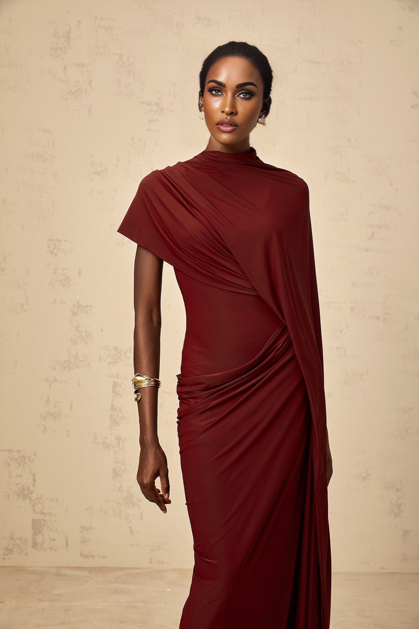 Woman wearing a matching asymmetrical draped cape and dress set in a flowy fabric