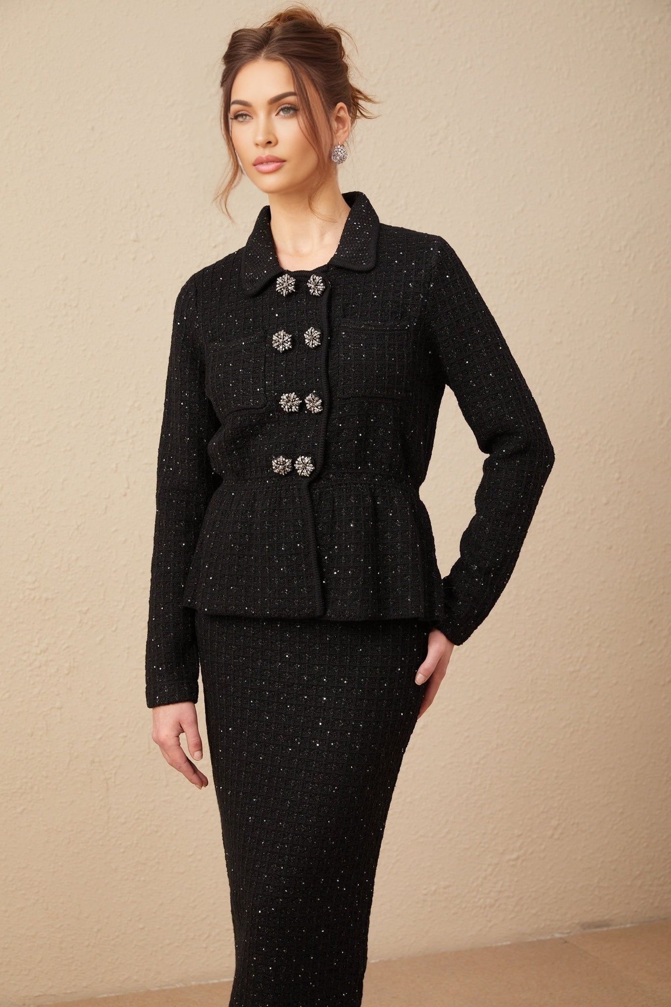 Woman wearing a matching sequined waffle knit jacket and skirt set in a shimmering fabric named Amina