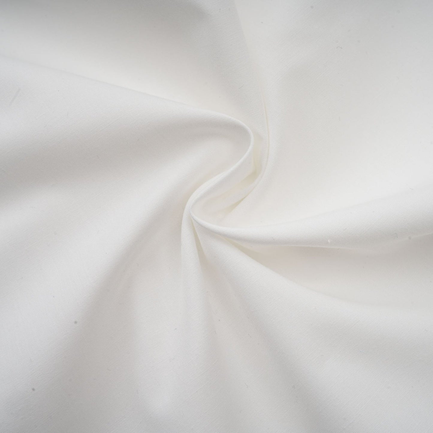 Woman wearing a matching set consisting of a cropped top and trousers in white lace fabric with cutout details