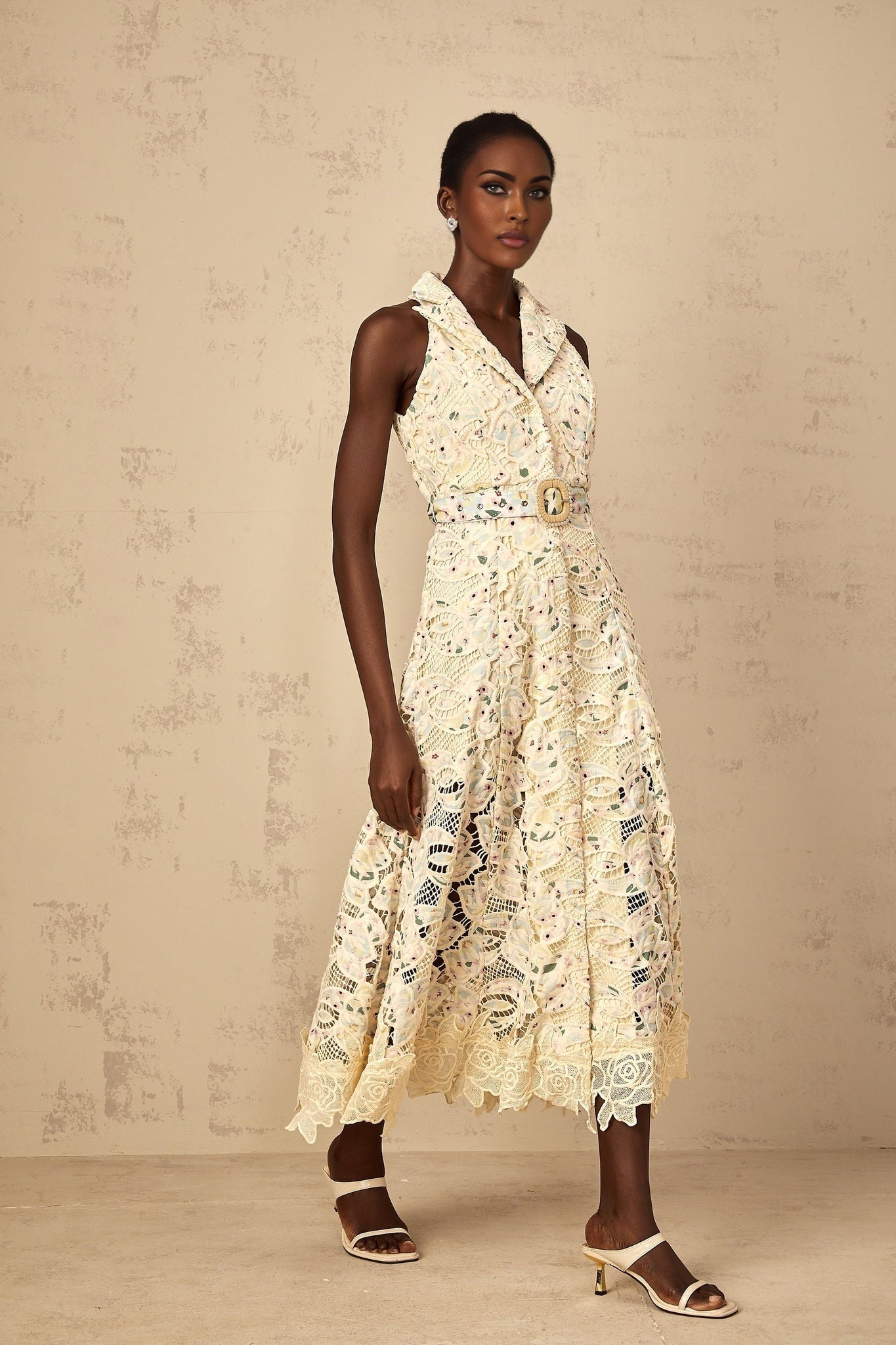 Woman wearing a midi length dress with floral embroidery and cutout details