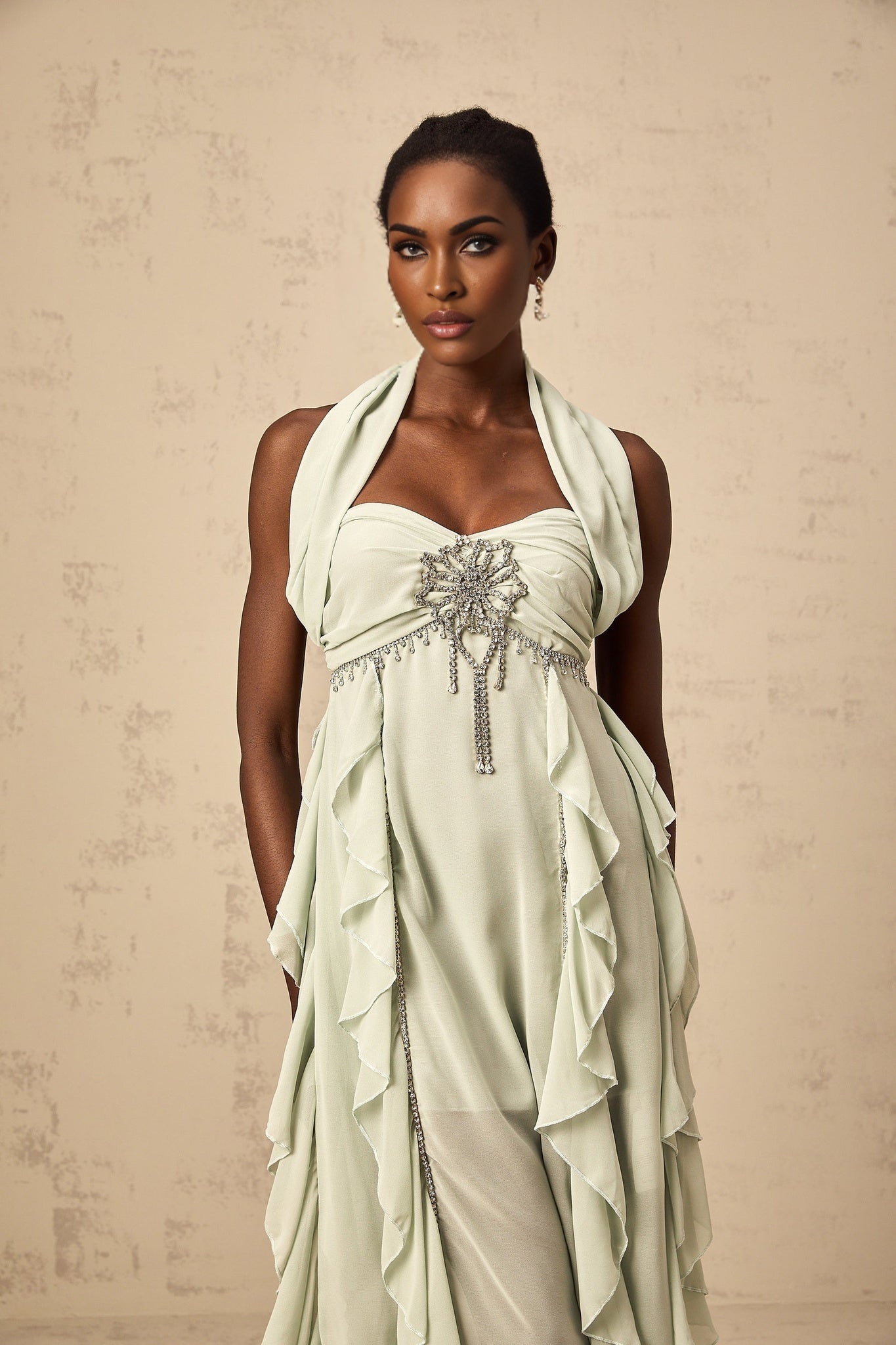 Woman wearing a midi length dress with ruffled details and embellishments