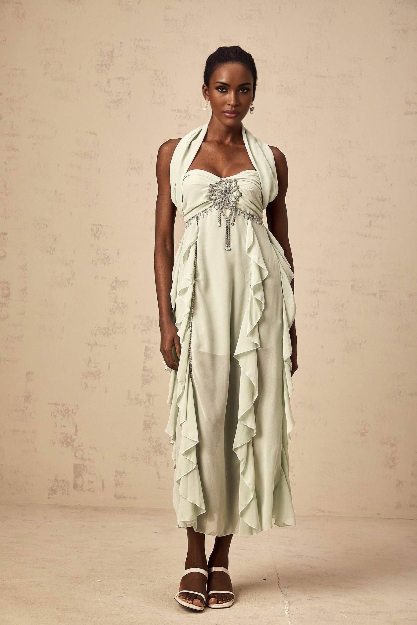 Woman wearing a midi length dress with ruffles and embellishments