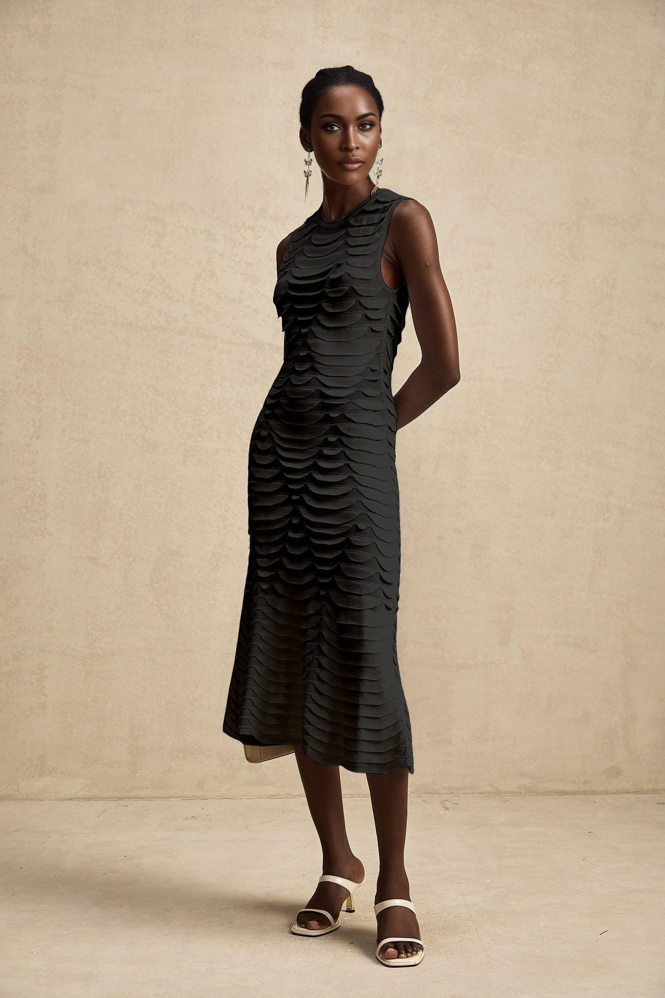Woman wearing a midi length dress with snake pattern design and godet skirt panels