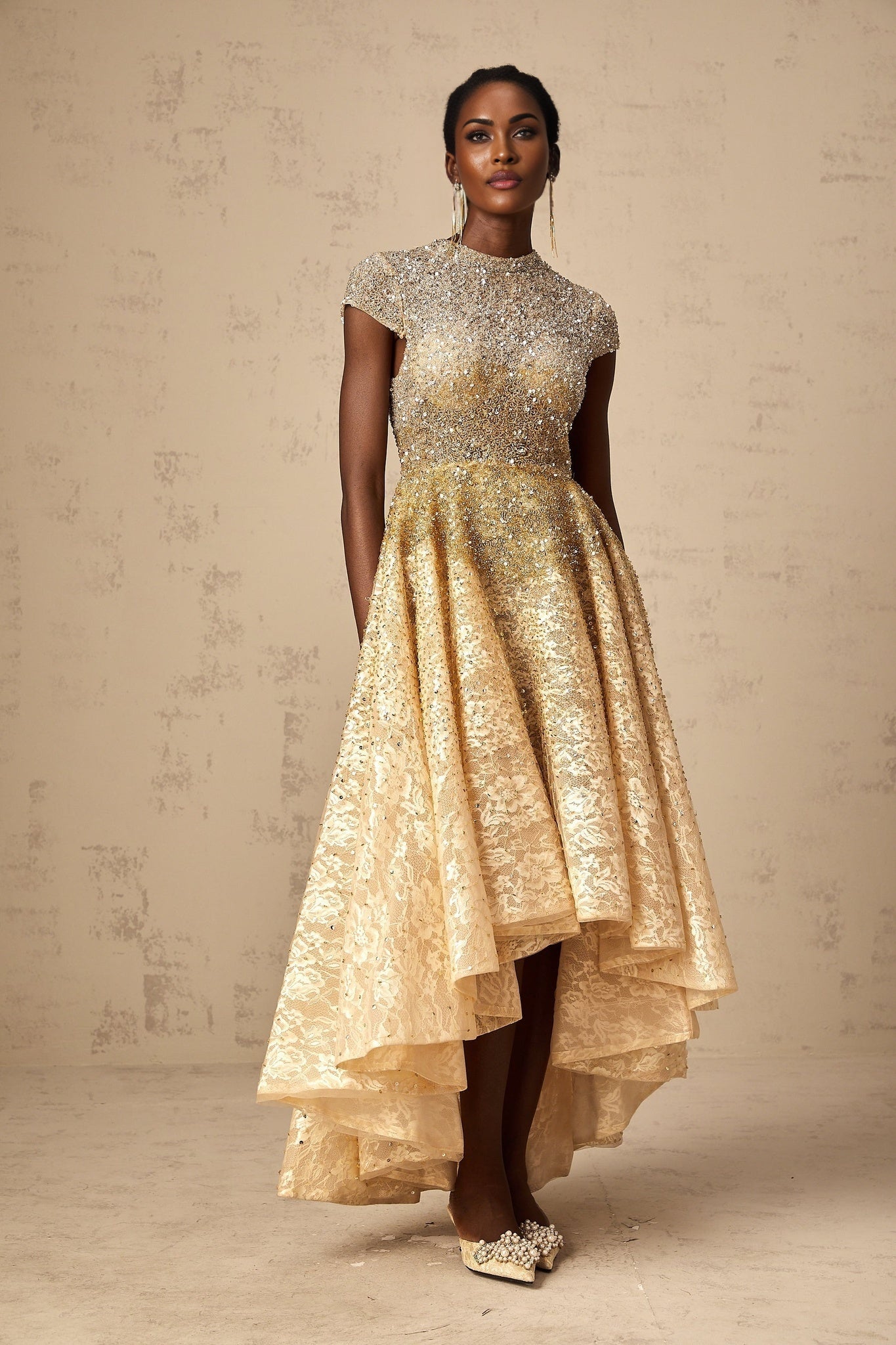 Woman wearing a neutral colored sequined dress with high low hemline