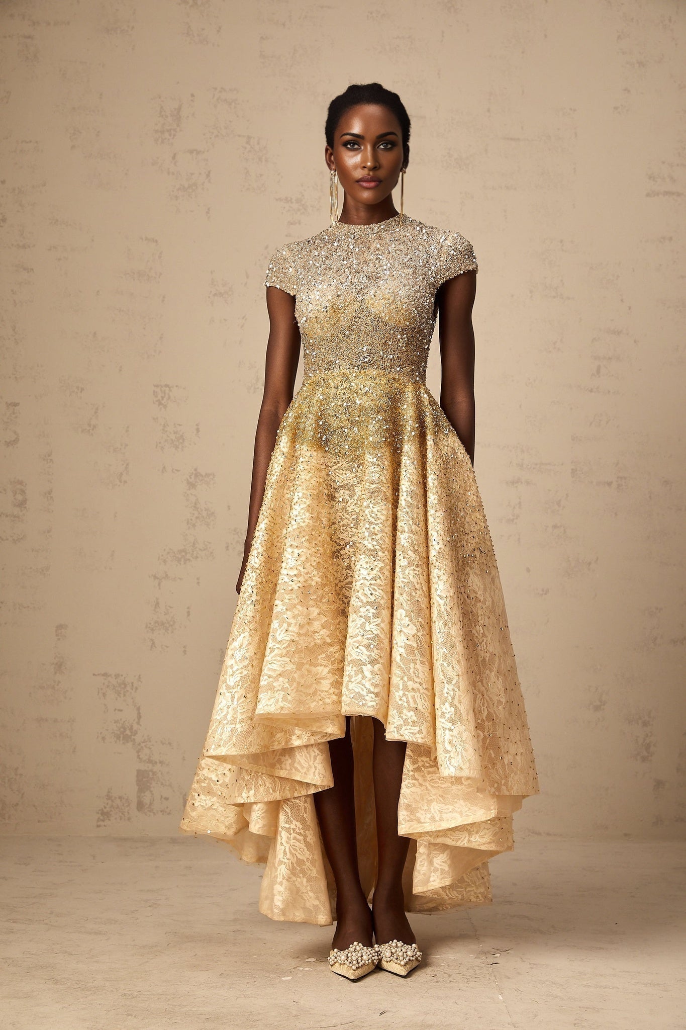 Woman wearing a neutral colored sequined dress with high low hemline