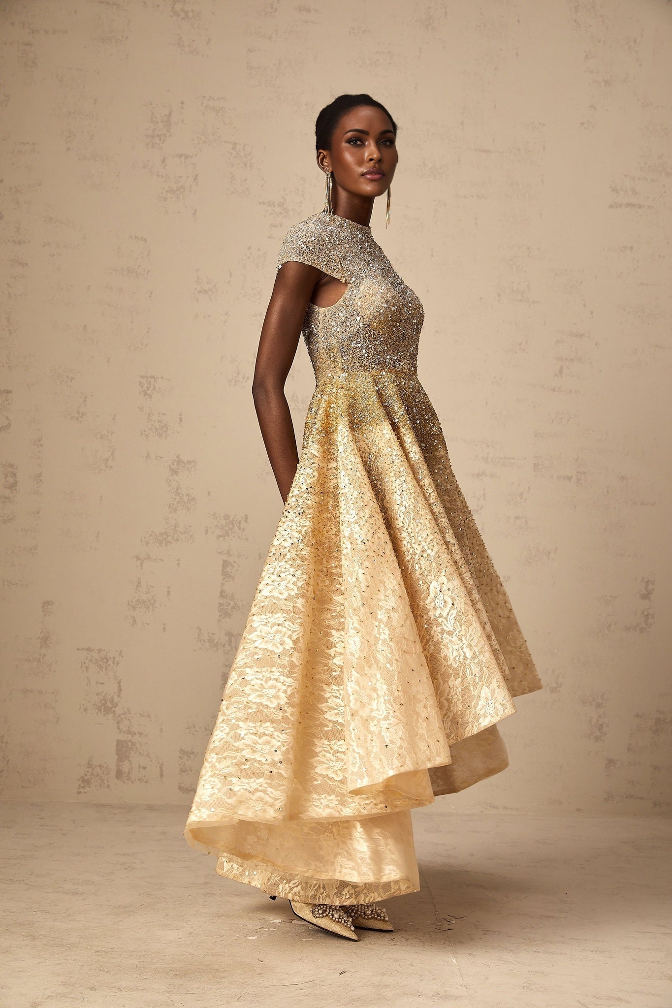 Woman wearing a neutral colored sequined dress with high low hemline