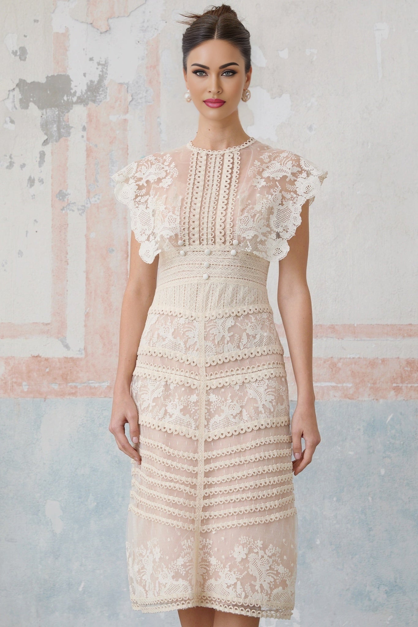 Woman wearing a neutralcolored midi dress with floral lace embroidery and sheer detailing