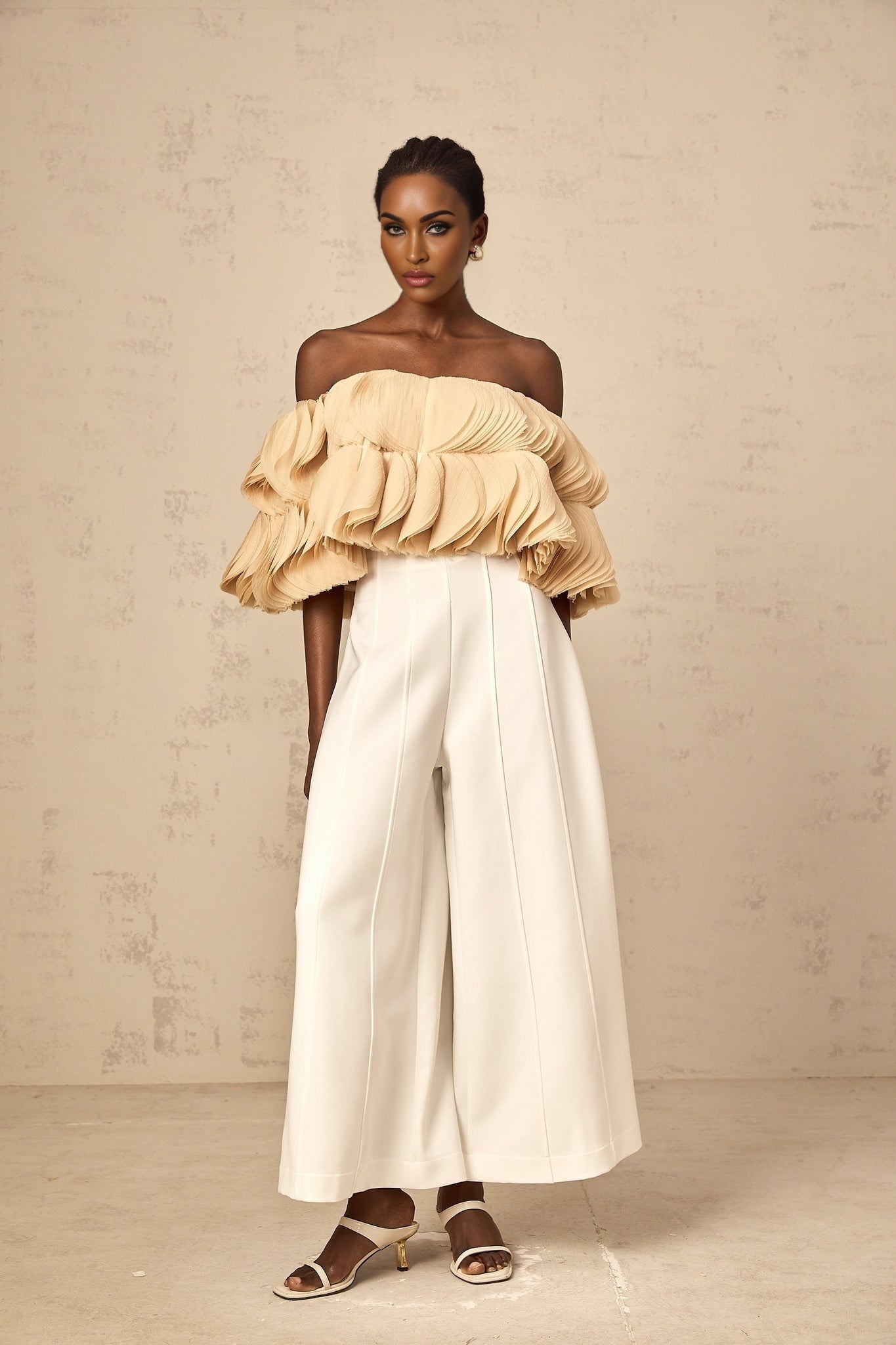 Woman wearing a neutralcolored offshoulder cropped top with shirred detailing
