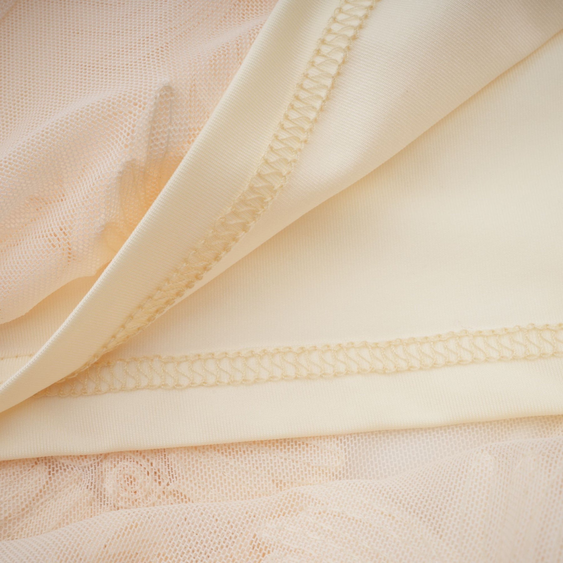 Woman wearing a neutralcolored offshoulder maxi dress with embroidery details standing in a relaxed pose