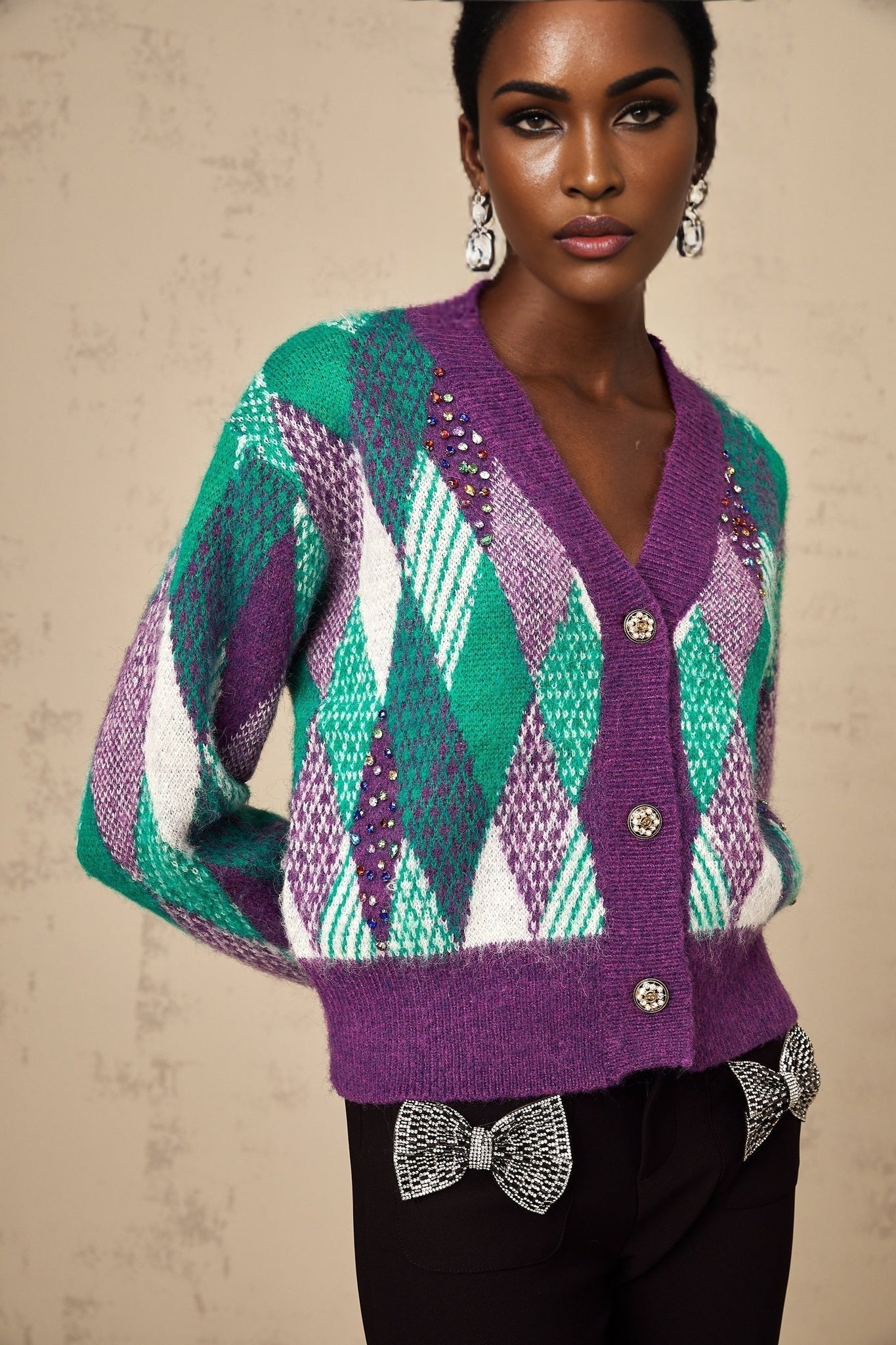 Woman wearing a purple knit top with argyle pattern long sleeves and round neckline