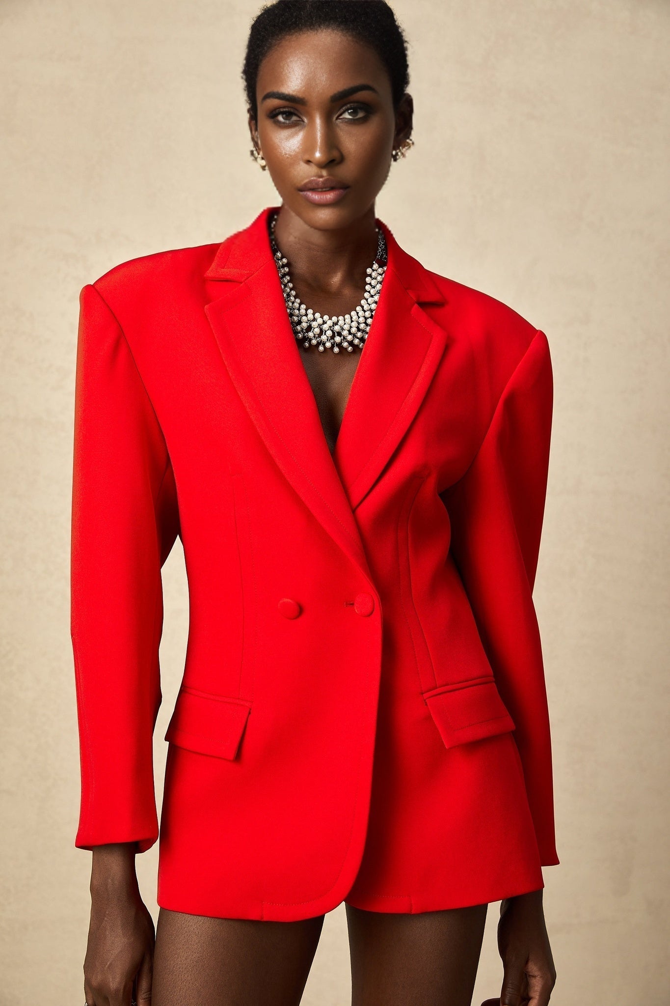 Woman wearing a red hourglass shaped double breasted blazer called Coline
