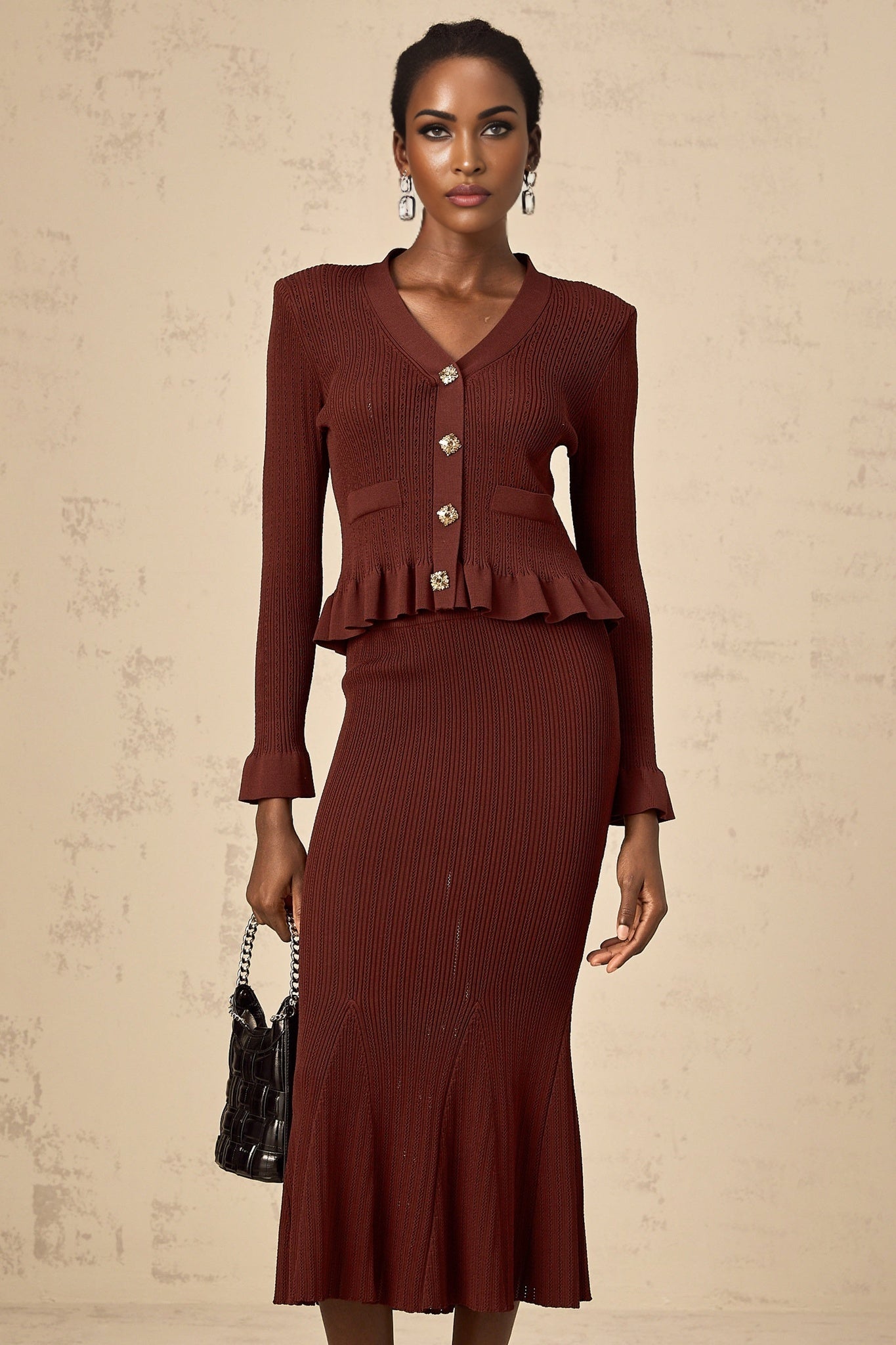 Woman wearing a red knit matching set consisting of a ruffled top and skirt