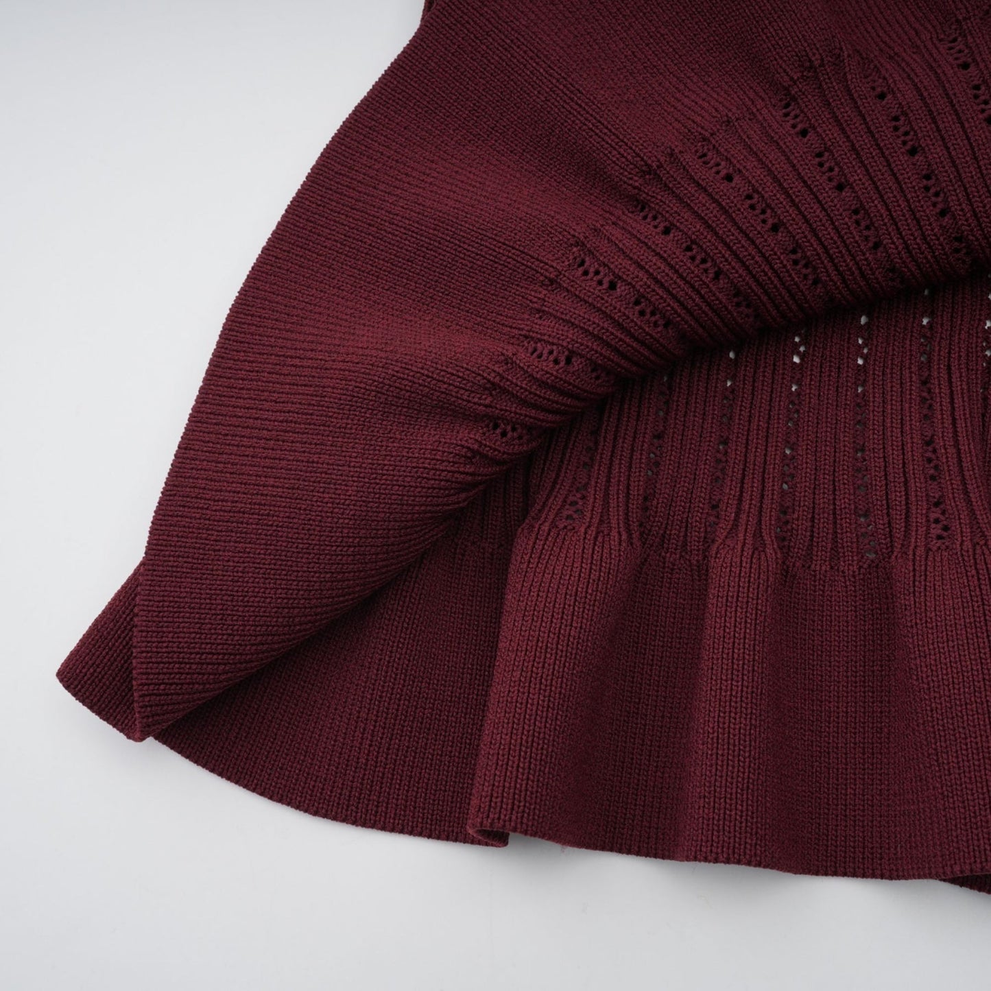 Woman wearing a red knit matching set with ruffled top and skirt named Corrine