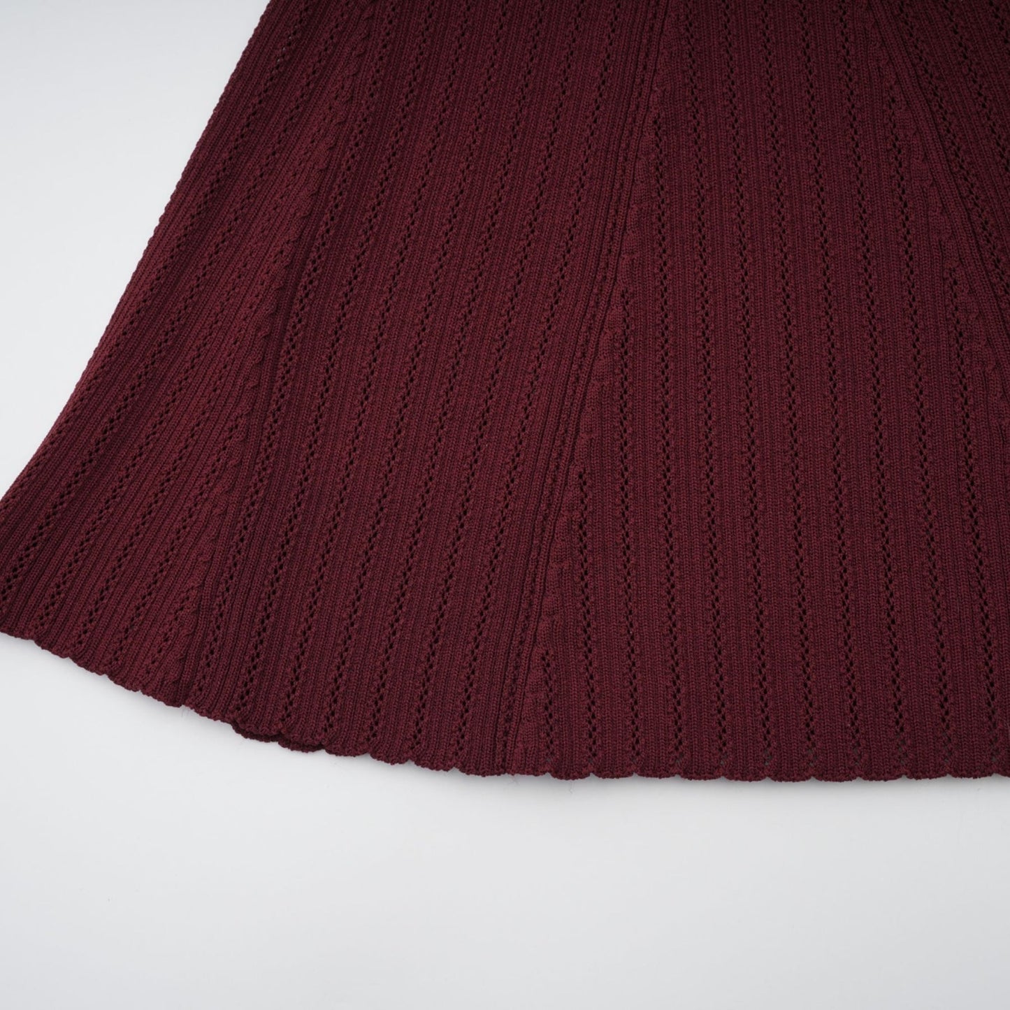 Woman wearing a red knit top with ruffled details and matching skirt set