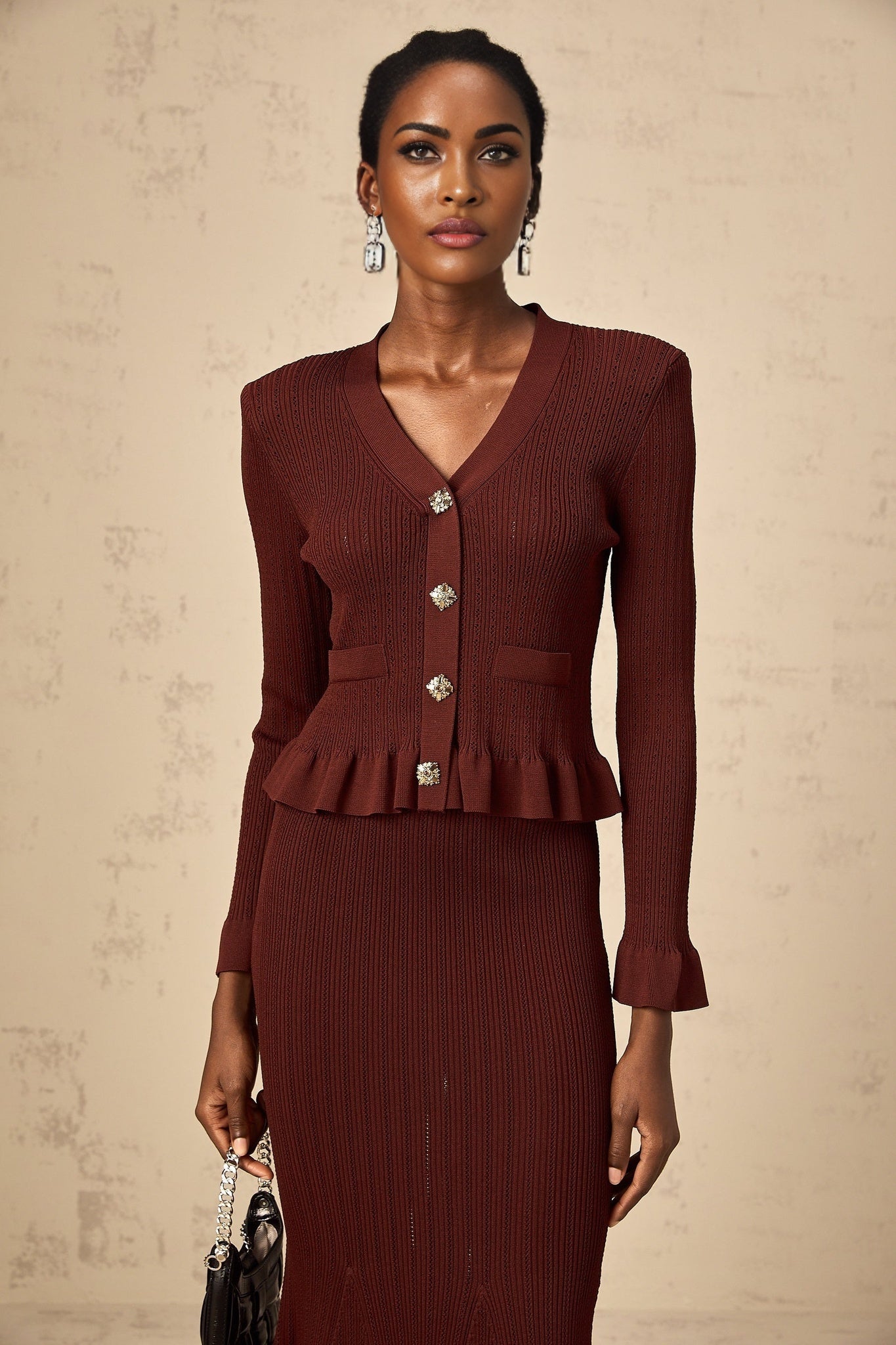 Woman wearing a red knit top with ruffles and matching skirt set called Corrine