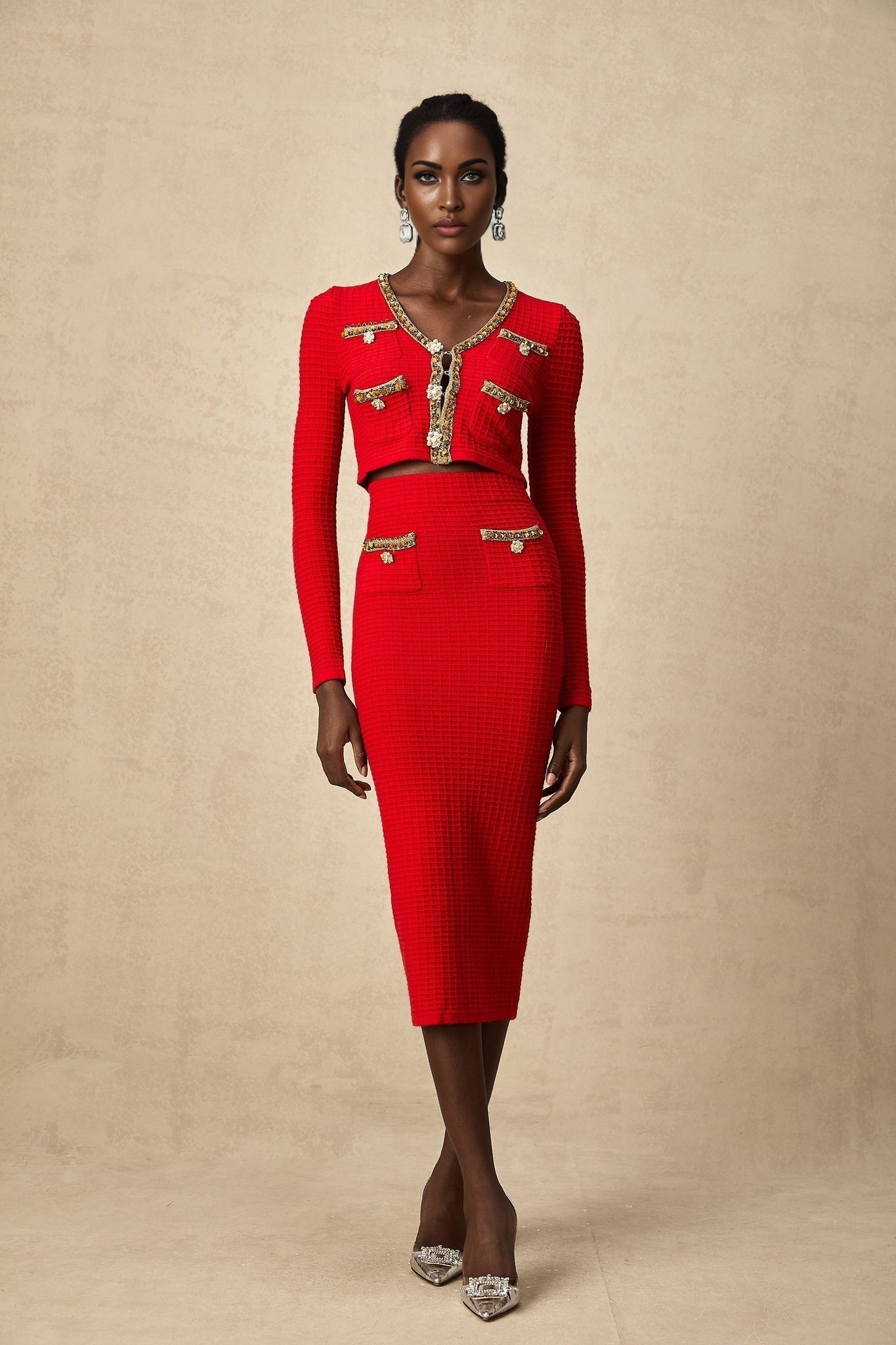 Woman wearing a red knitted cardigan and matching skirt set with embellishments named Axelle